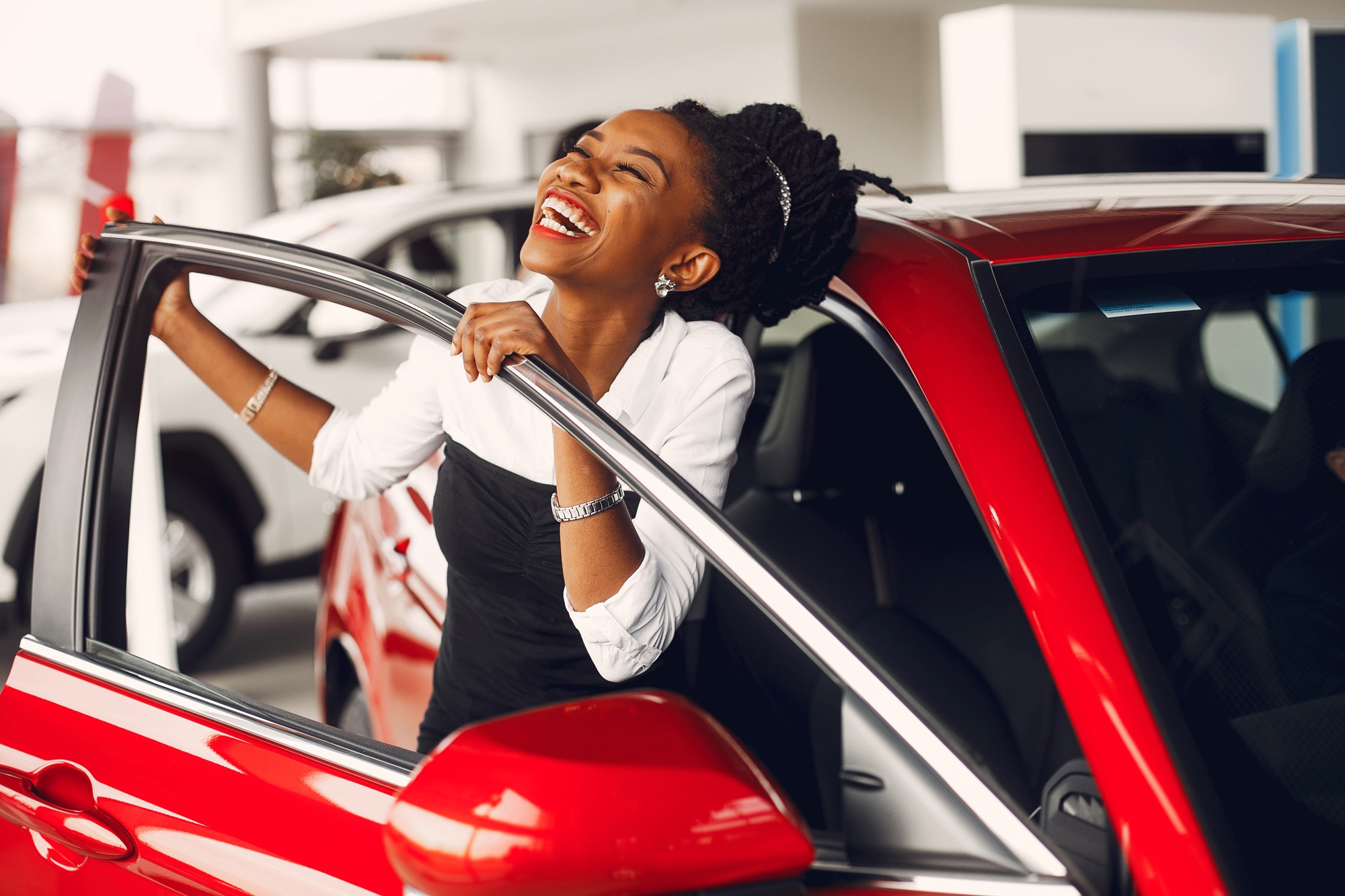A woman opening the door of a new car