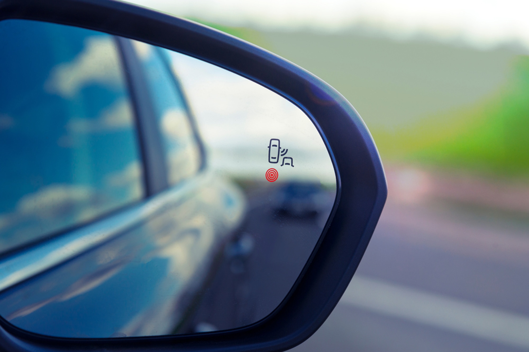 Blind zone monitoring sensor on the side mirror of a modern car