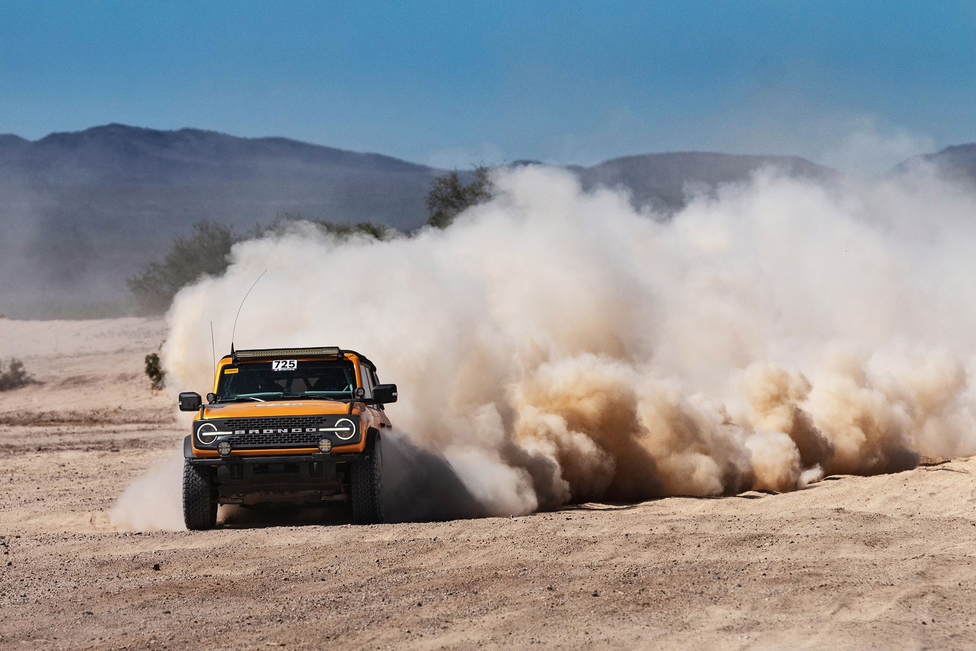 Yellow Ford Bronco hooning in the desert.