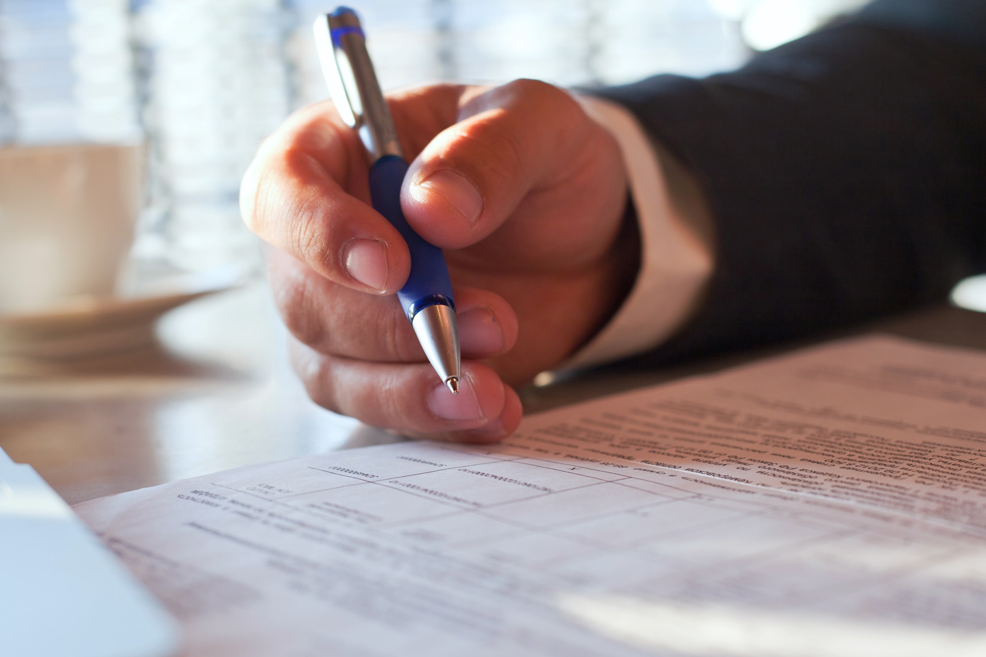 Close up of hand with pen and document