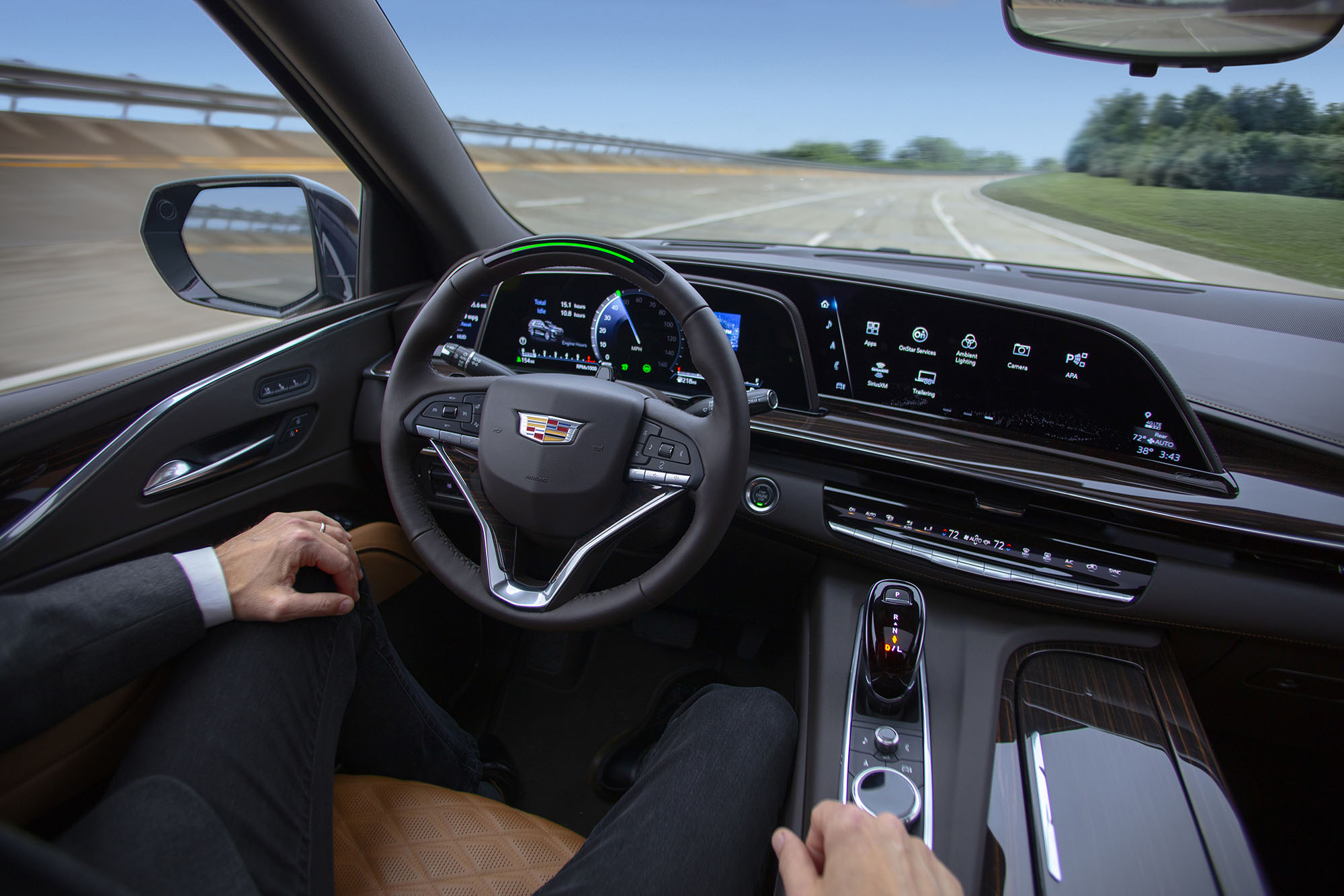 Person sits behind wheel of vehicle on the road with hands in their lap