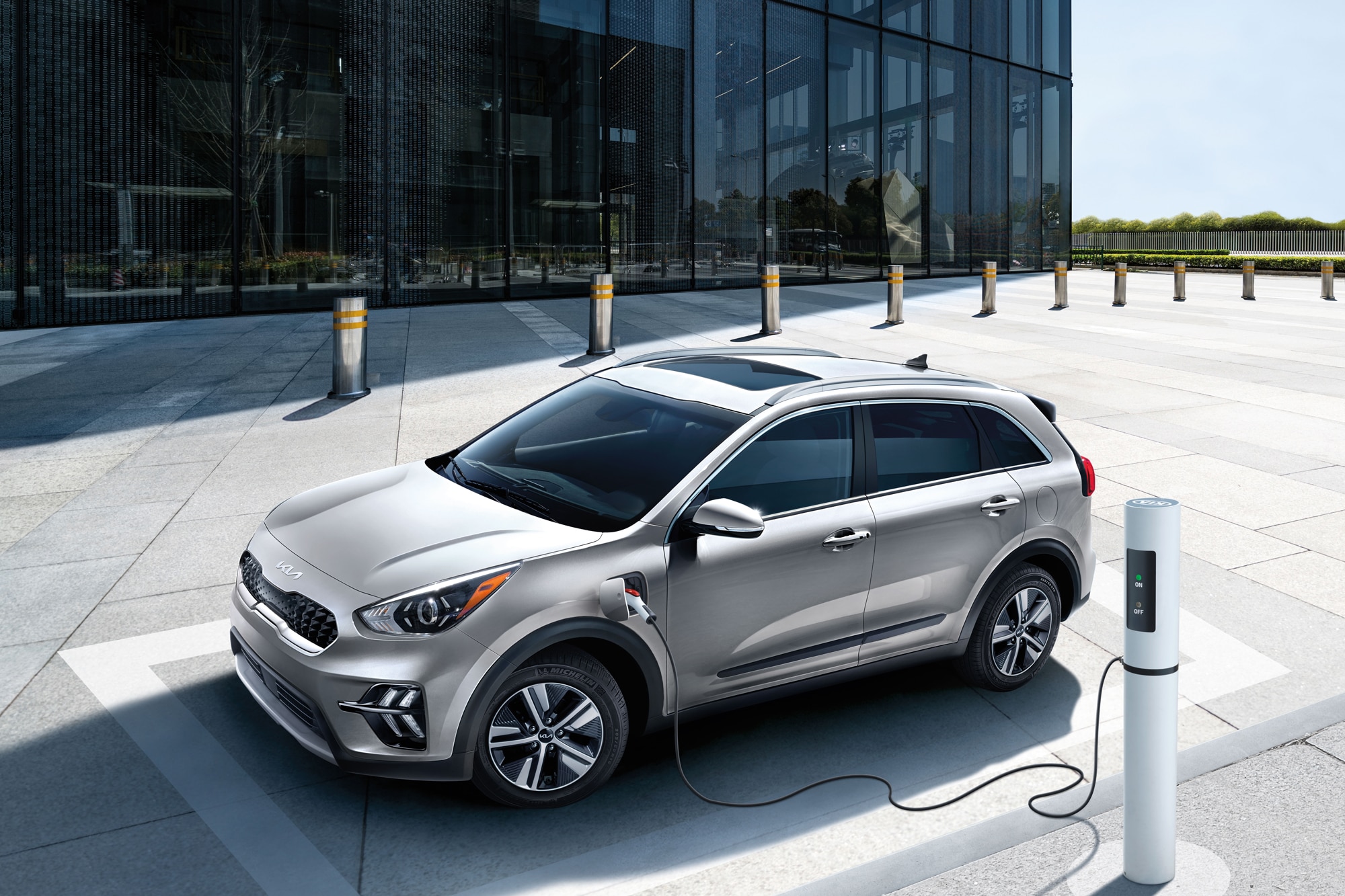 Kia Niro PHEV charging in front of glass building