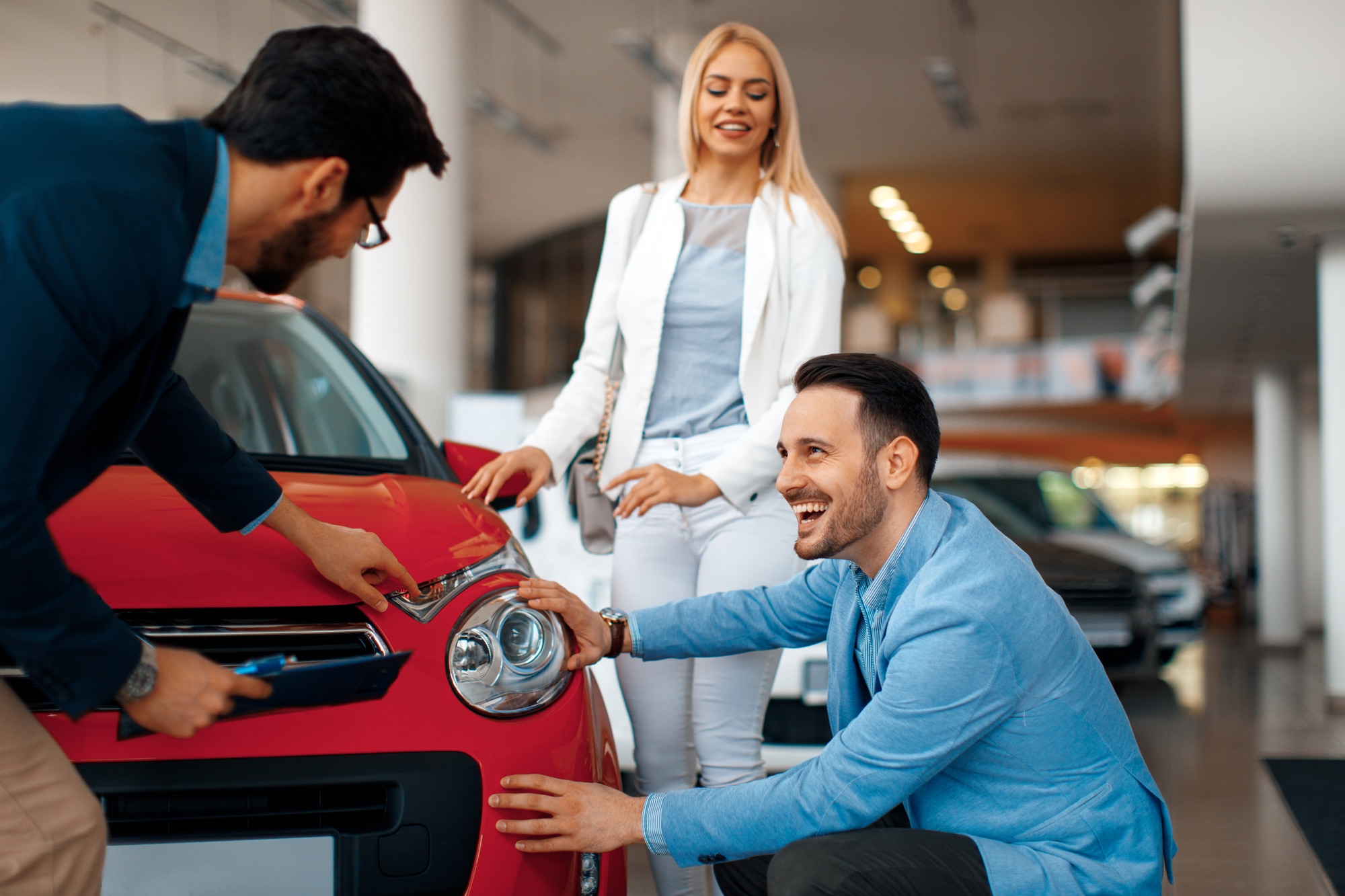 Young couple choosing new car in dealership