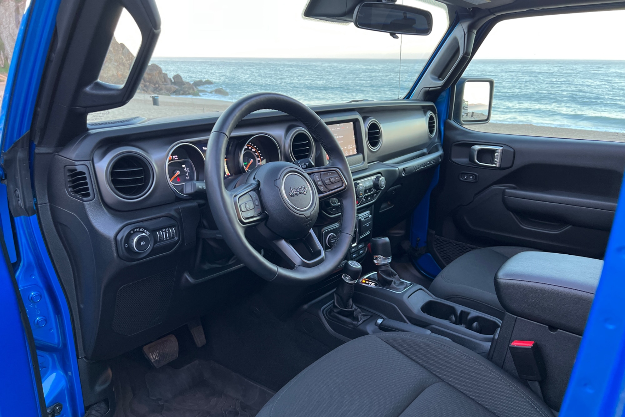 2022 Jeep Wrangler High Tide interior dashboard with view of sand and ocean