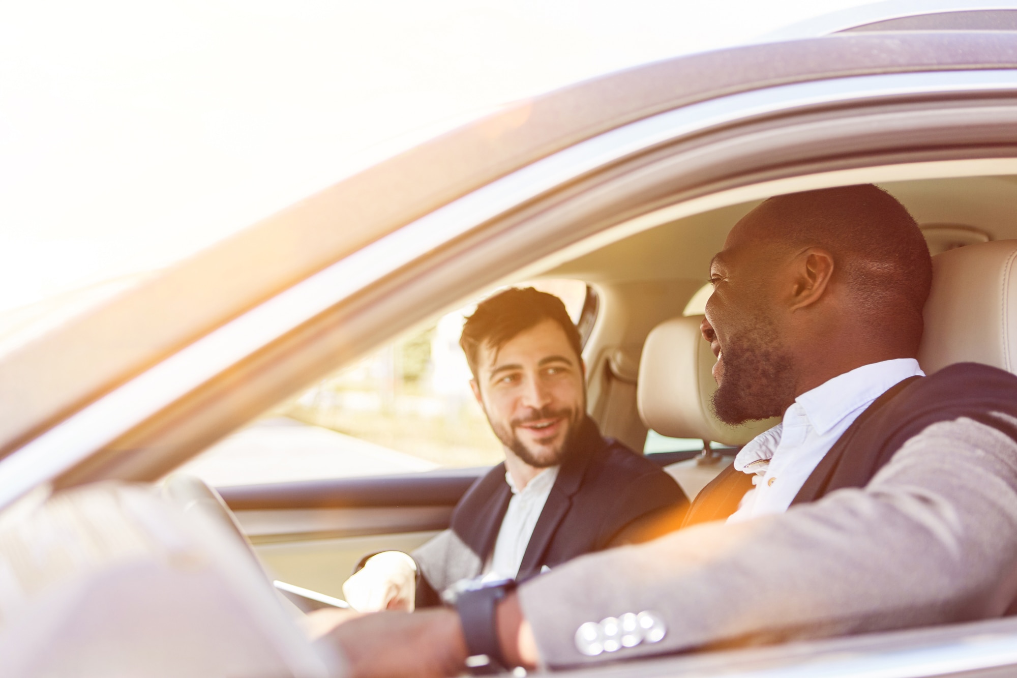 Black undefined white man in car smiling at each other