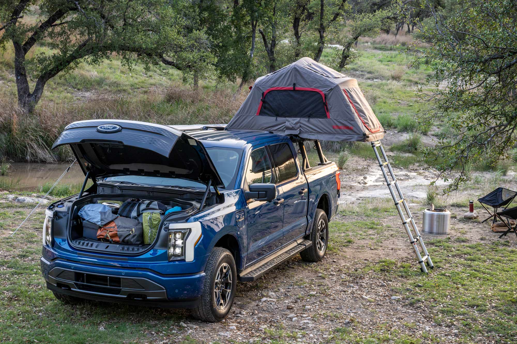 Blue 2022 Ford F-150 Lightning XLT set up with camping gear