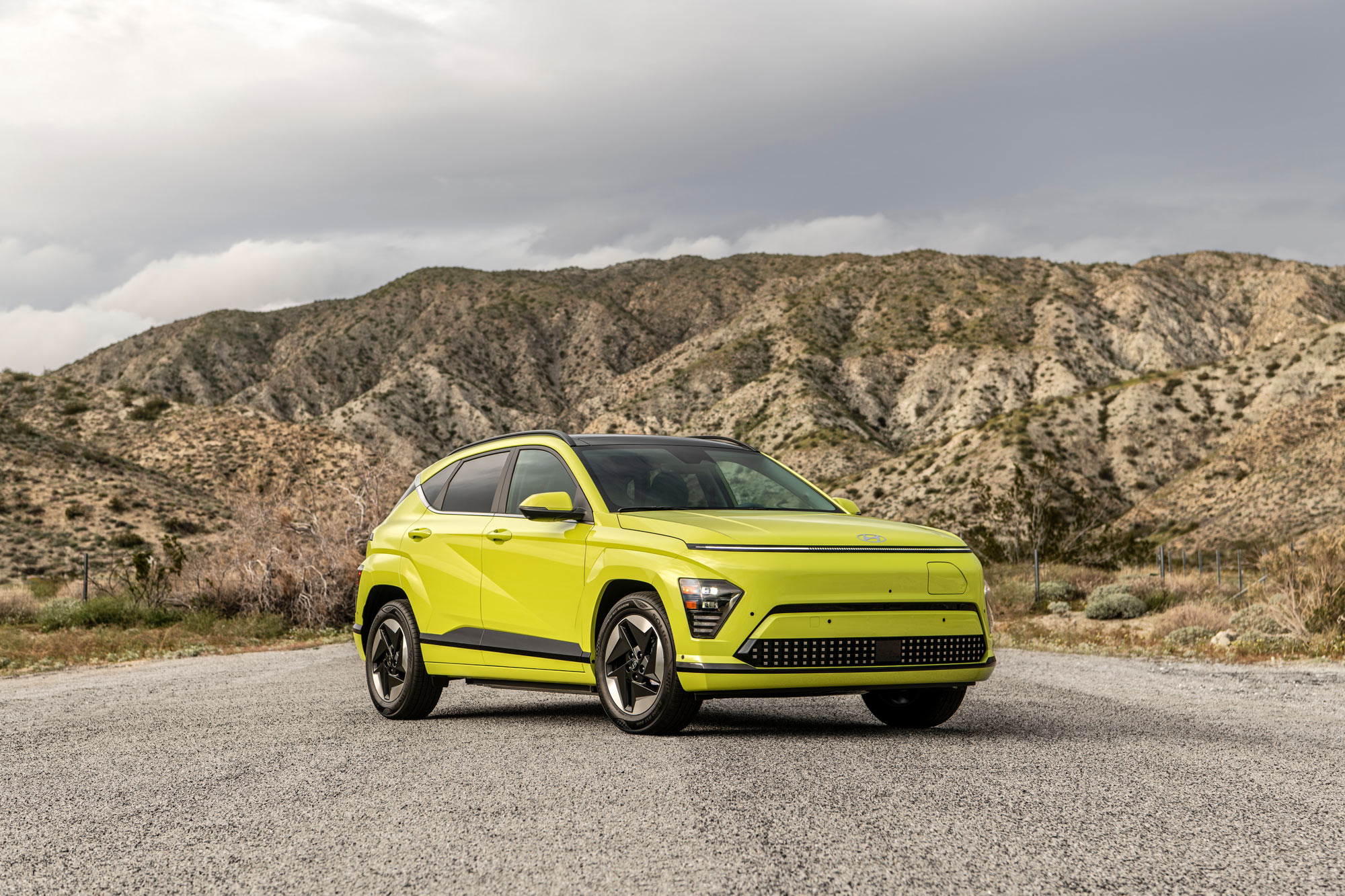 Neon 2024 Hyundai Kona Electric parked in front of desert hills