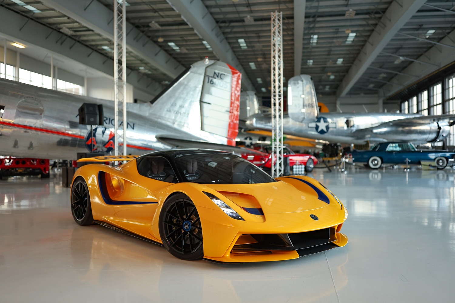 Lotus Evija parked in hangar by airplanes