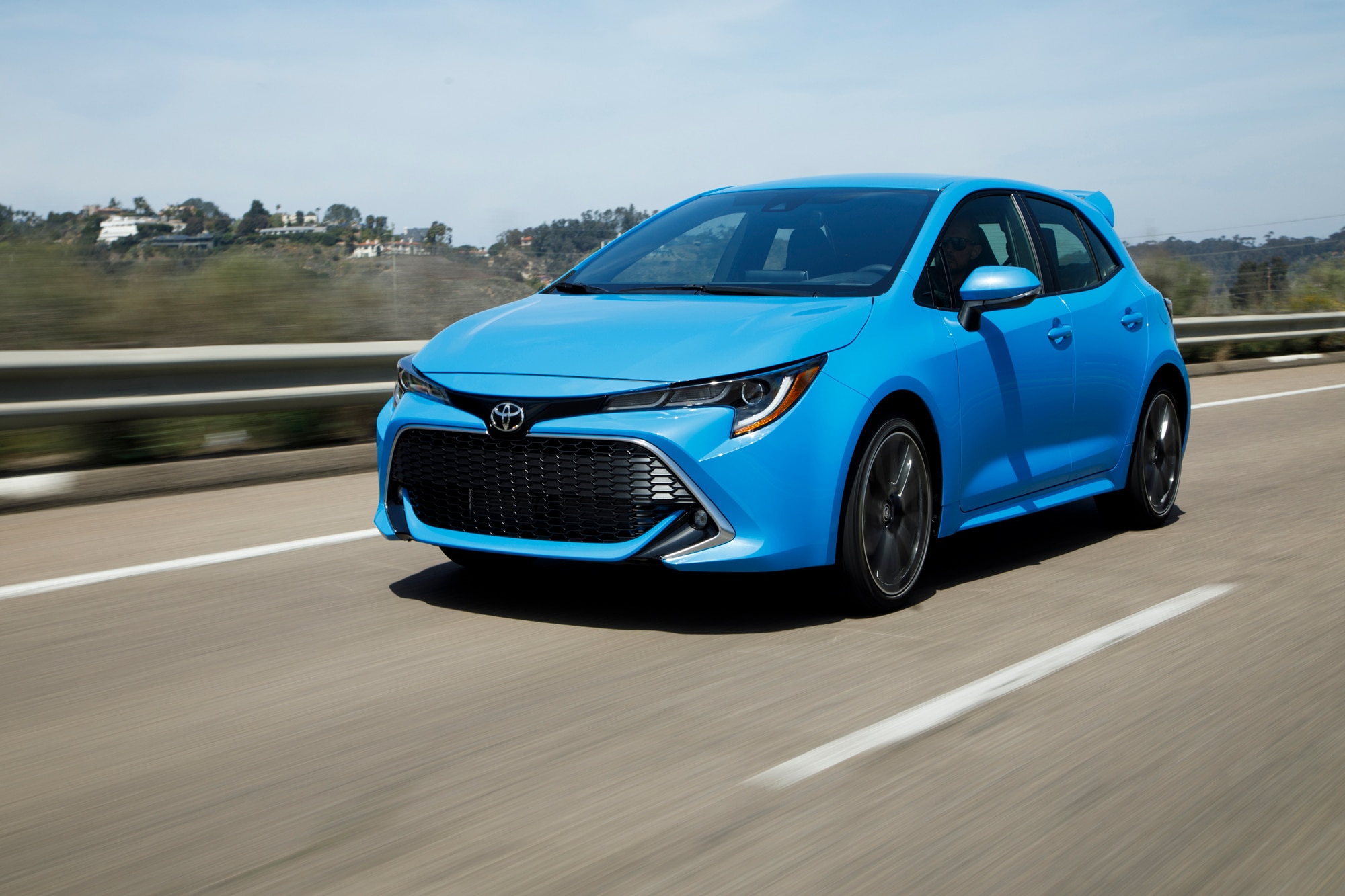Blue 2022 Toyota Corolla Hatchback driving down highway