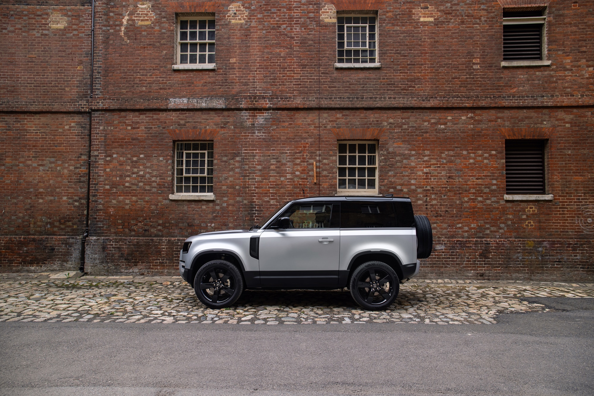 Gray 2021 Land Rover Defender parked outside brick building