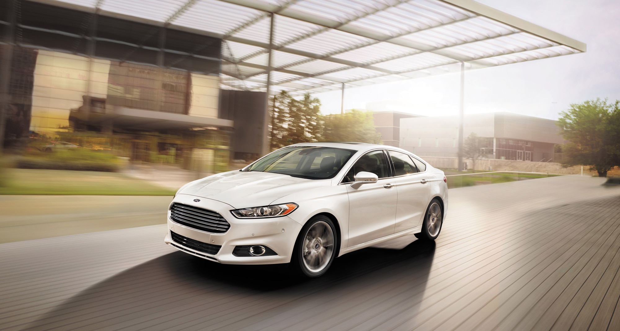 White 2014 Ford Fusion driving in front of building