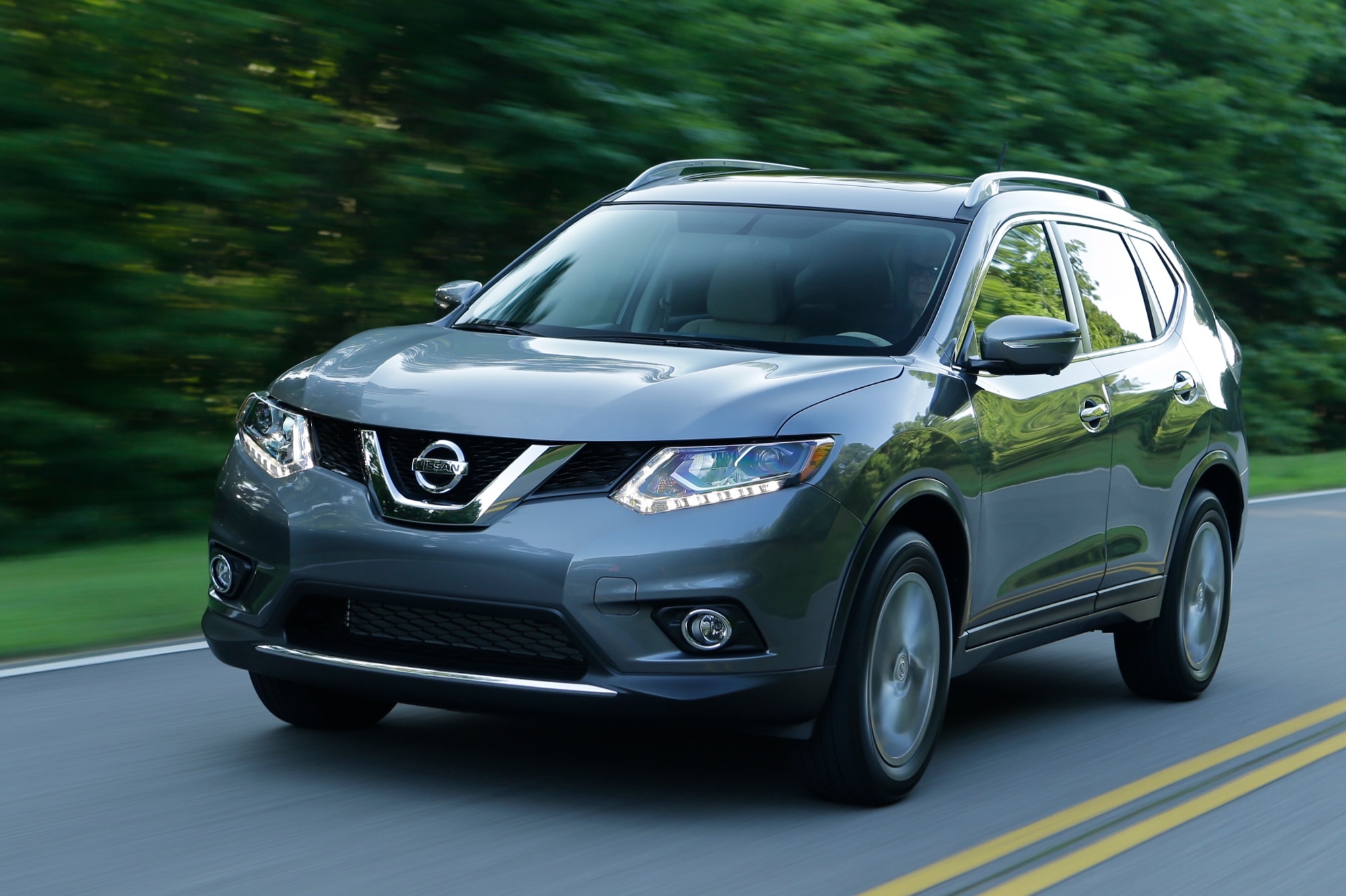 Blue 2014 Nissan Rogue on highway