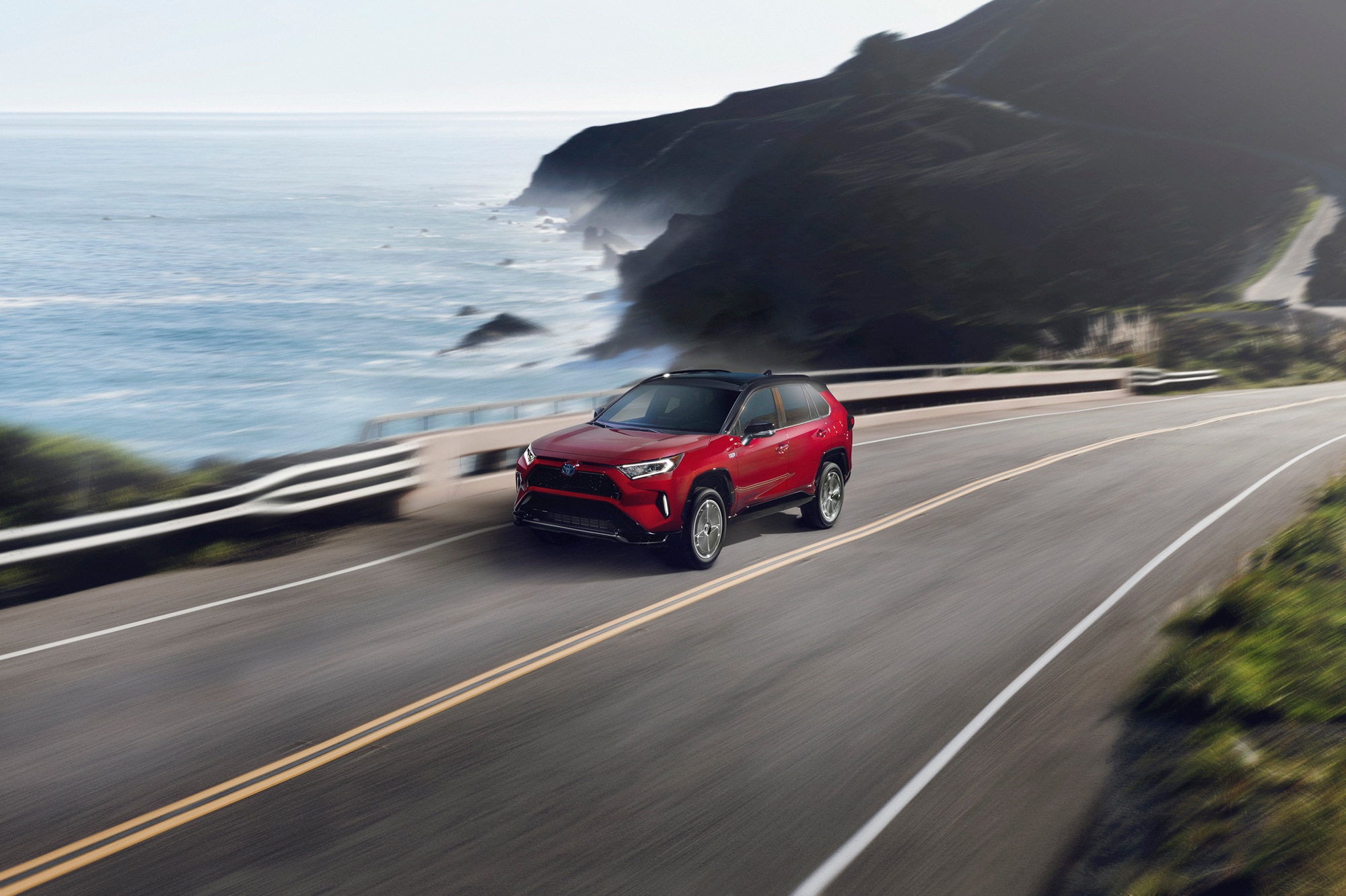 Red 2021 Toyota RAV4 Prime PHEV on the highway by the ocean