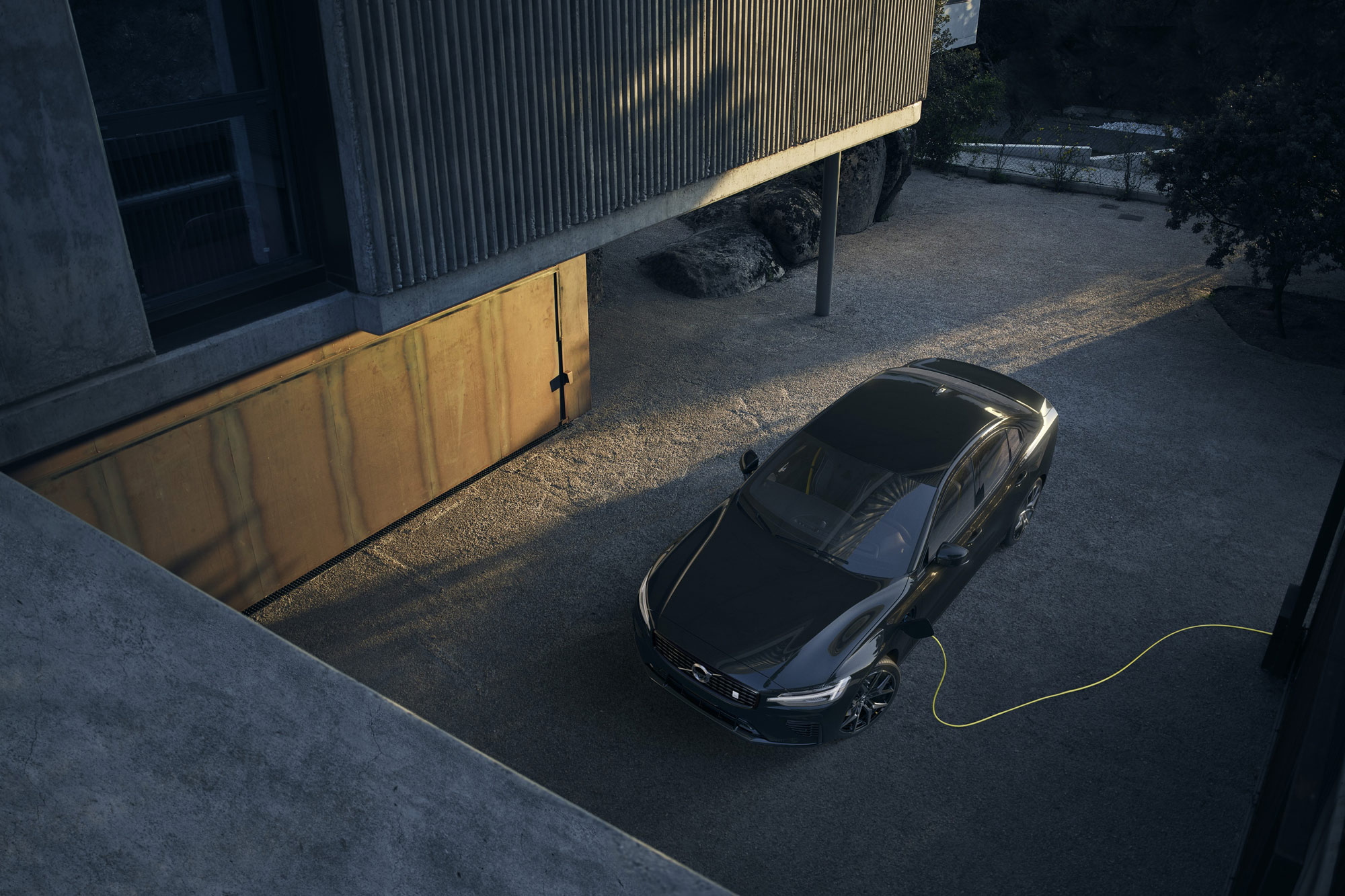 Black 2024 Volvo V60 Recharge Polestar Engineered charging outside a house