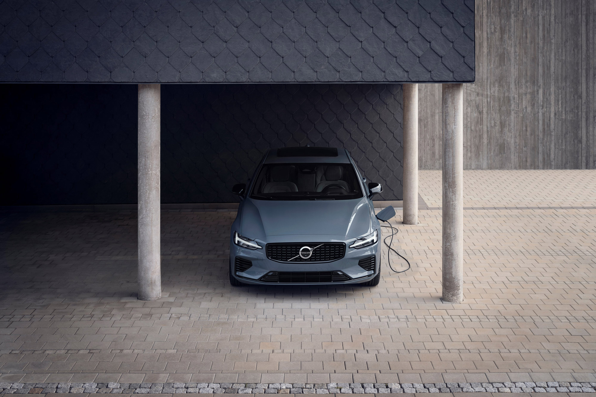Gray 2024 Volvo S60 Recharge T8 charging under covered parking
