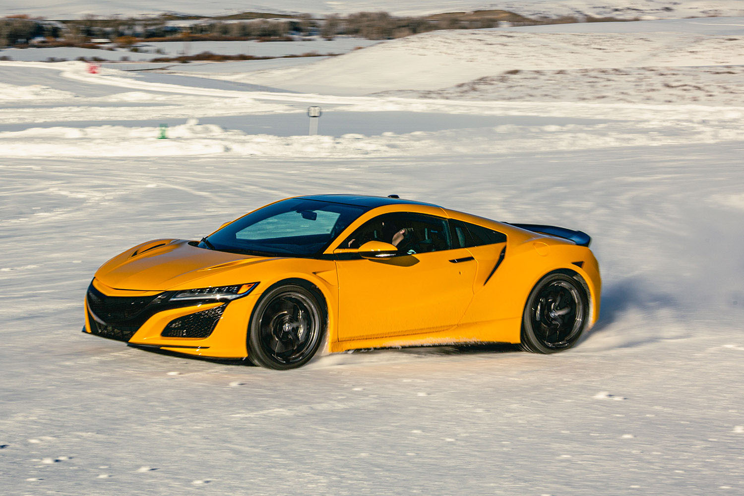 Mid-engine, exotic sports car driving on snow