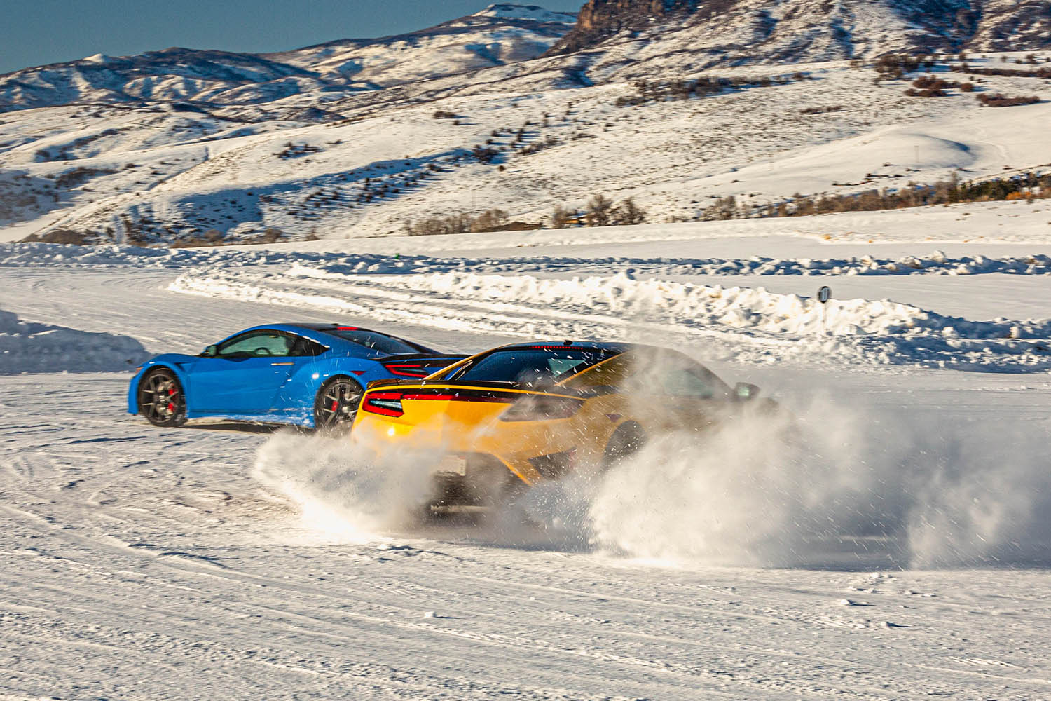 Mid-engine, exotic sports cars drifting on snow