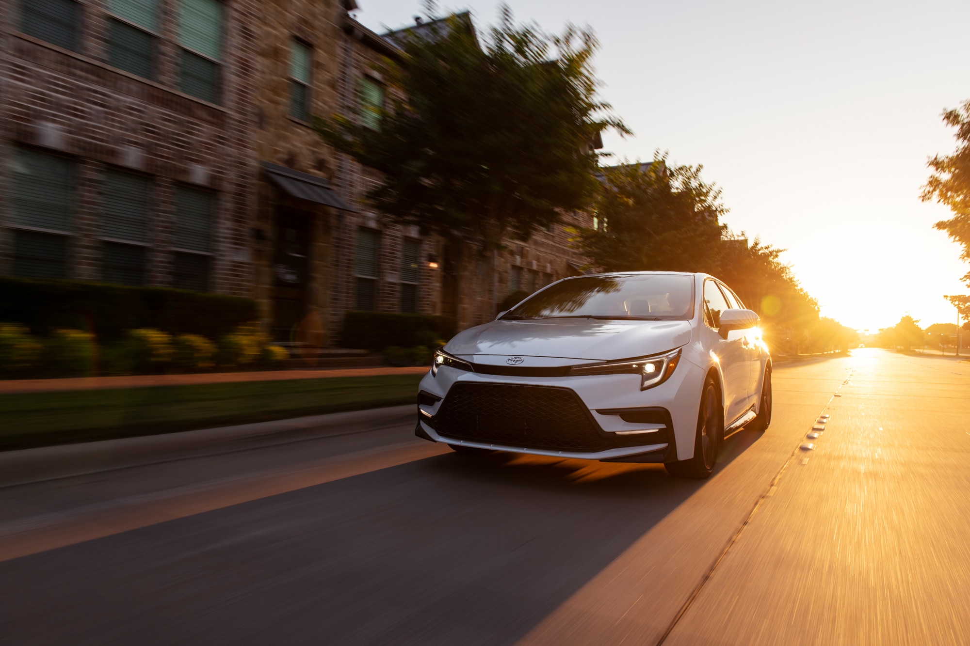 2023 Toyota Corolla XSE Wind Chill Pearl driving down street in sunset