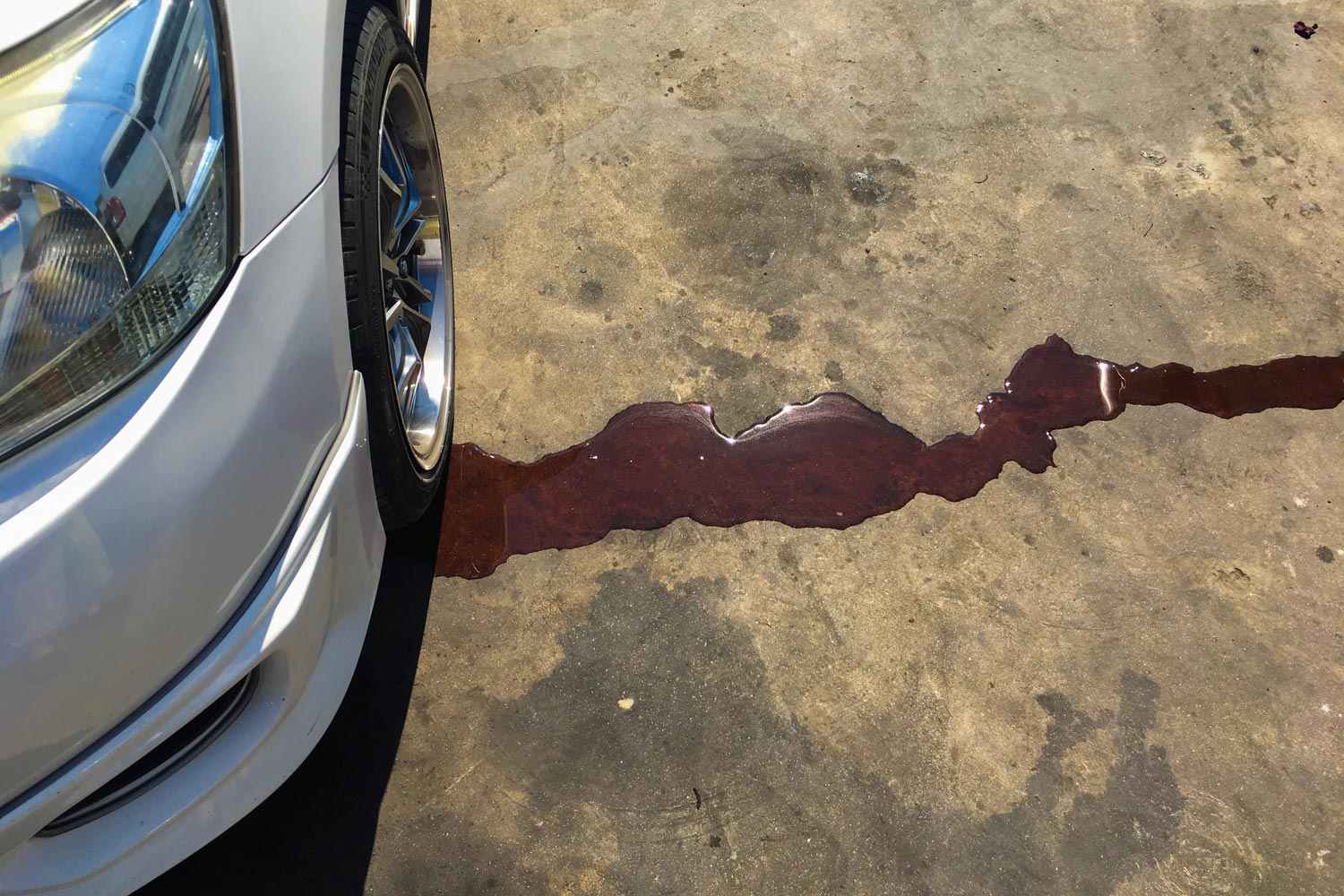 red coolant leaking from car onto ground