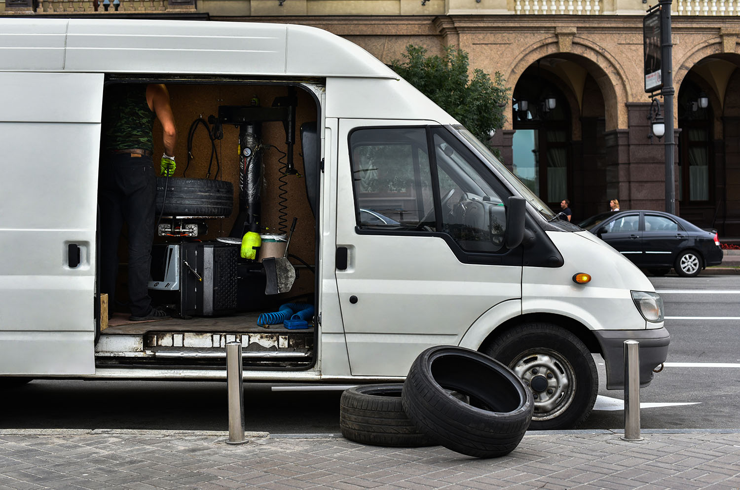 White van with open sliding door displaying mobile wheel-repair equipment