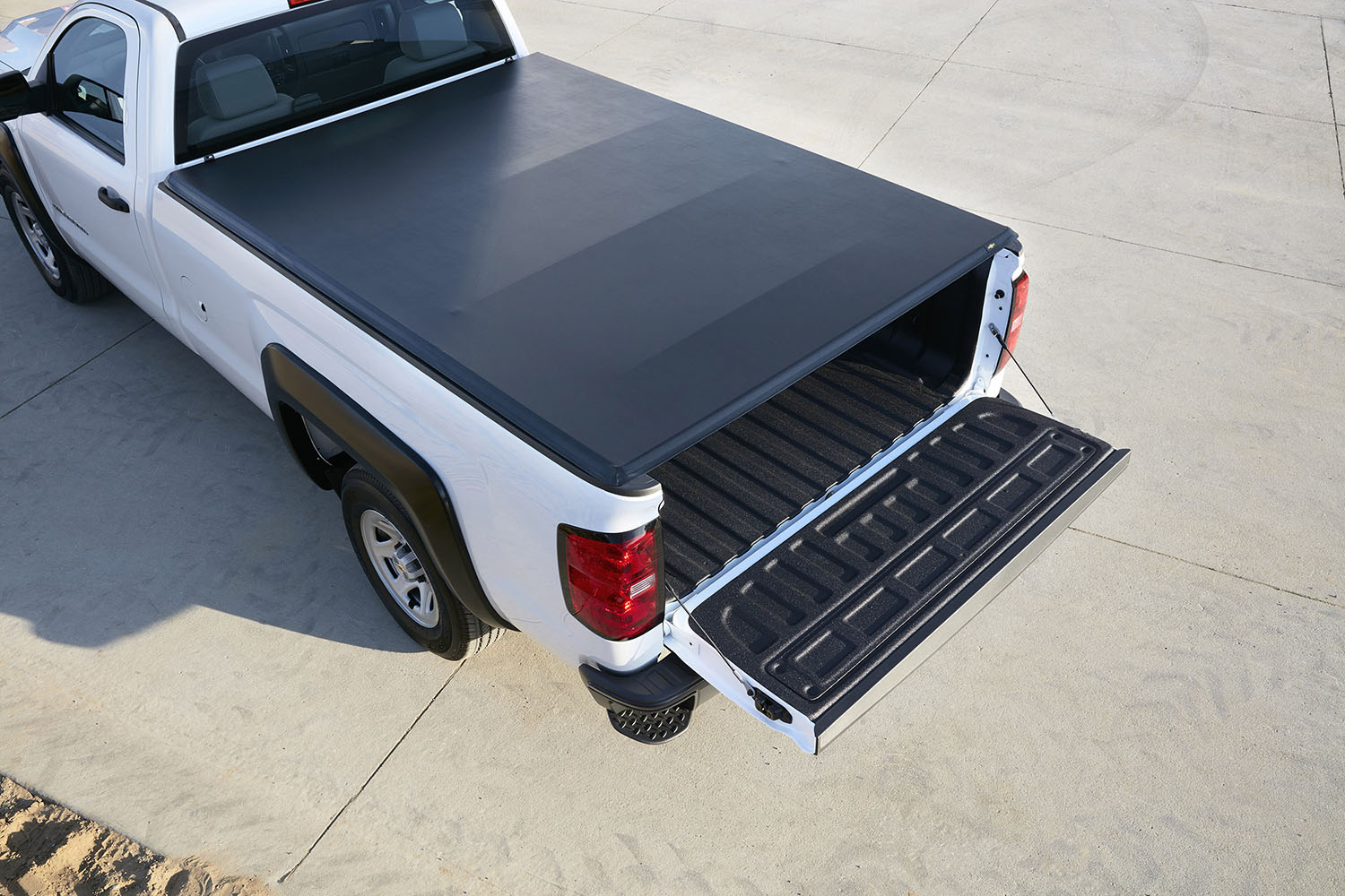 White pickup truck with a black tonneau cover over the bed