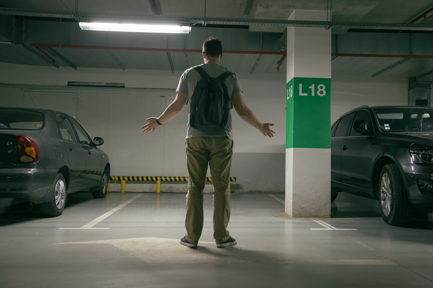 man in parking garage looking for stolen car