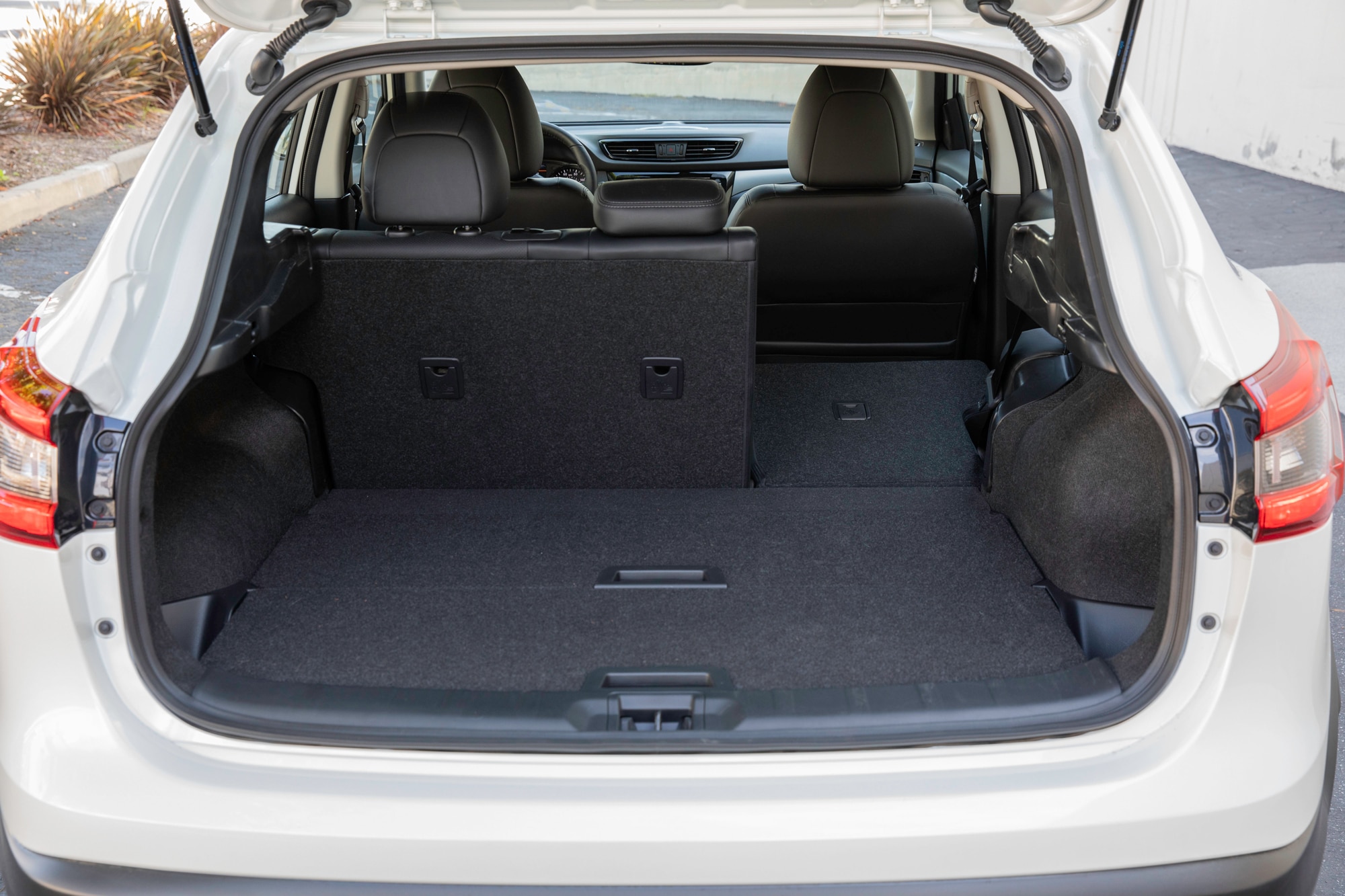White 2022 Nissan Rogue Sport trunk open with one back seat down 