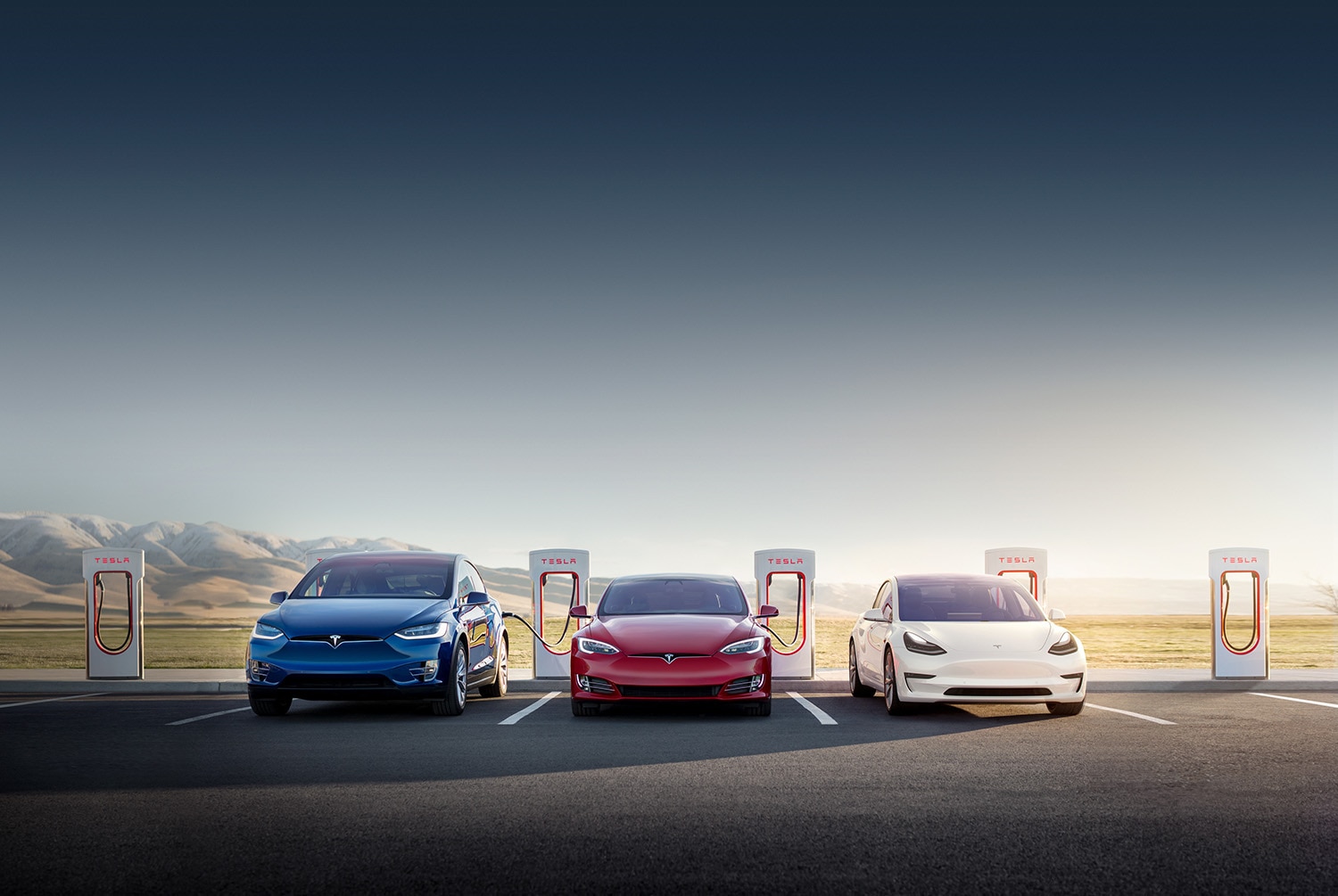 Three Teslas in red blue and white charging
