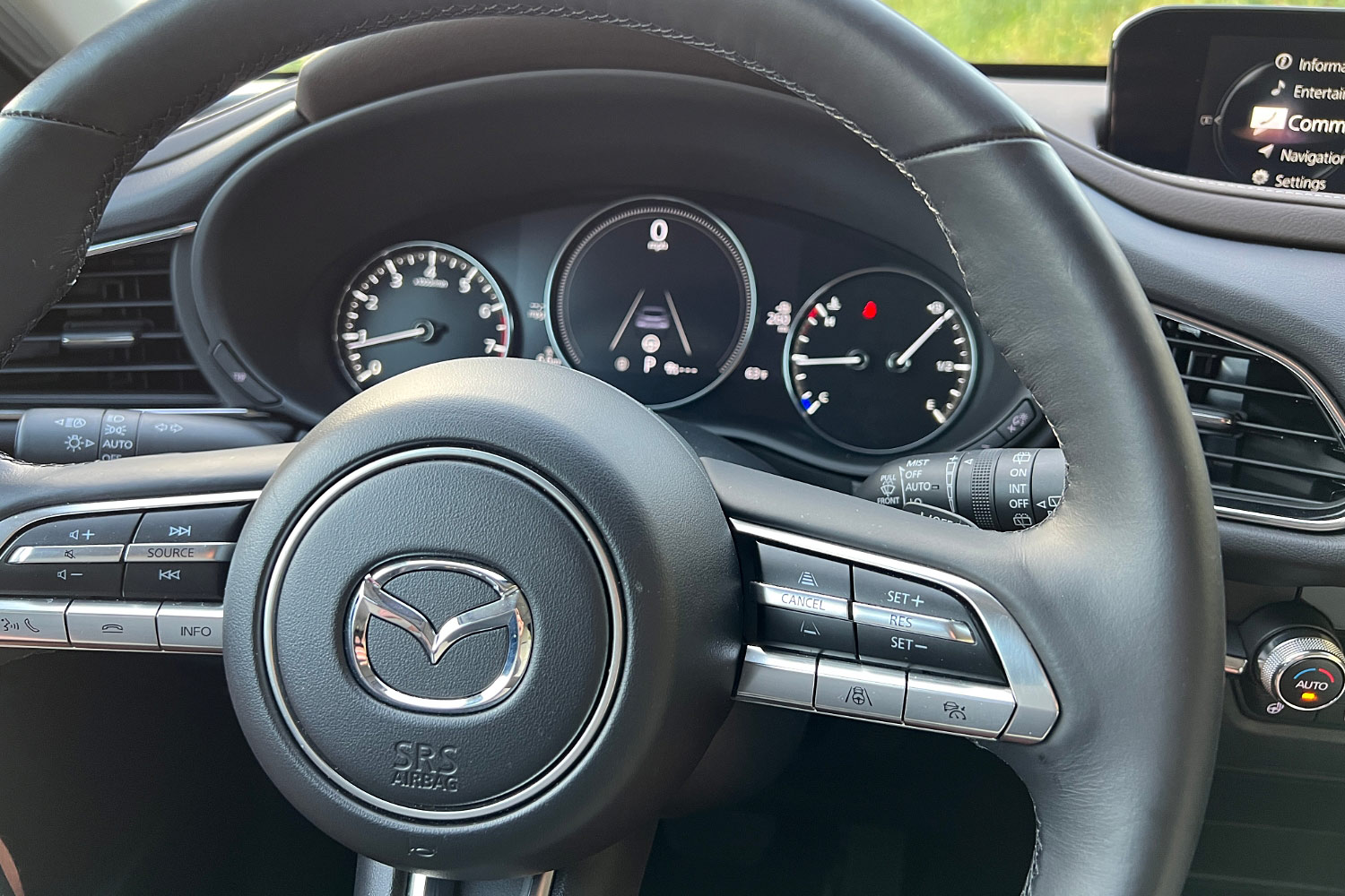 The steering wheel and driver's gauge panel on a Mazda CX-30.