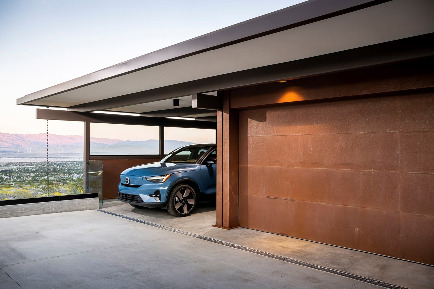 Blue Volvo parked next to a garage.