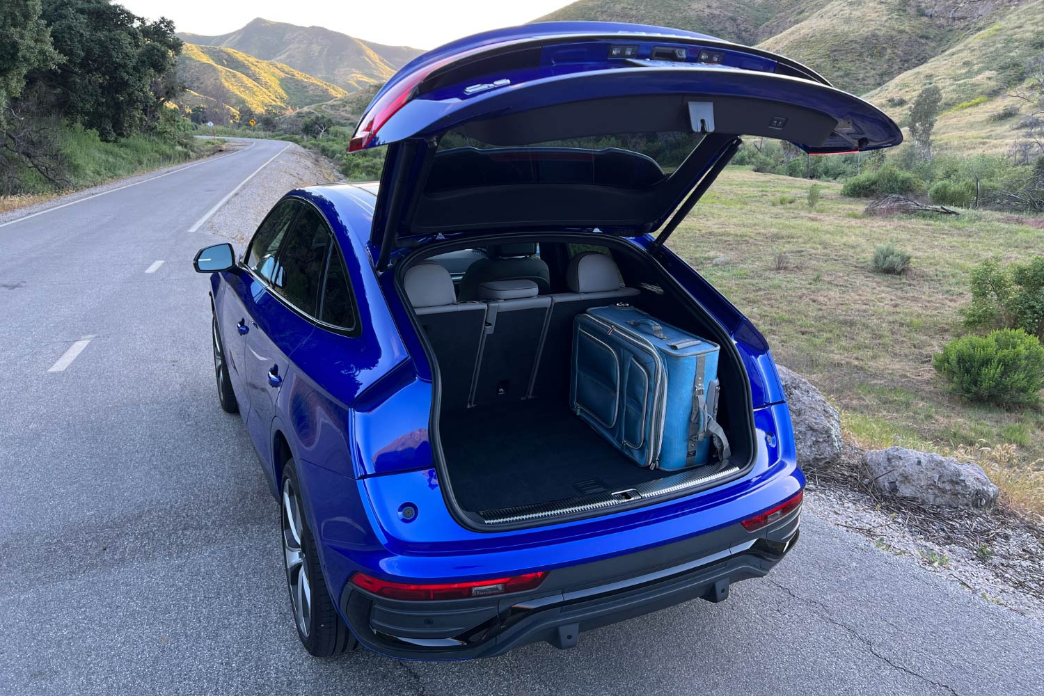Rear of a blue Audi Q5 with the back hatch open.