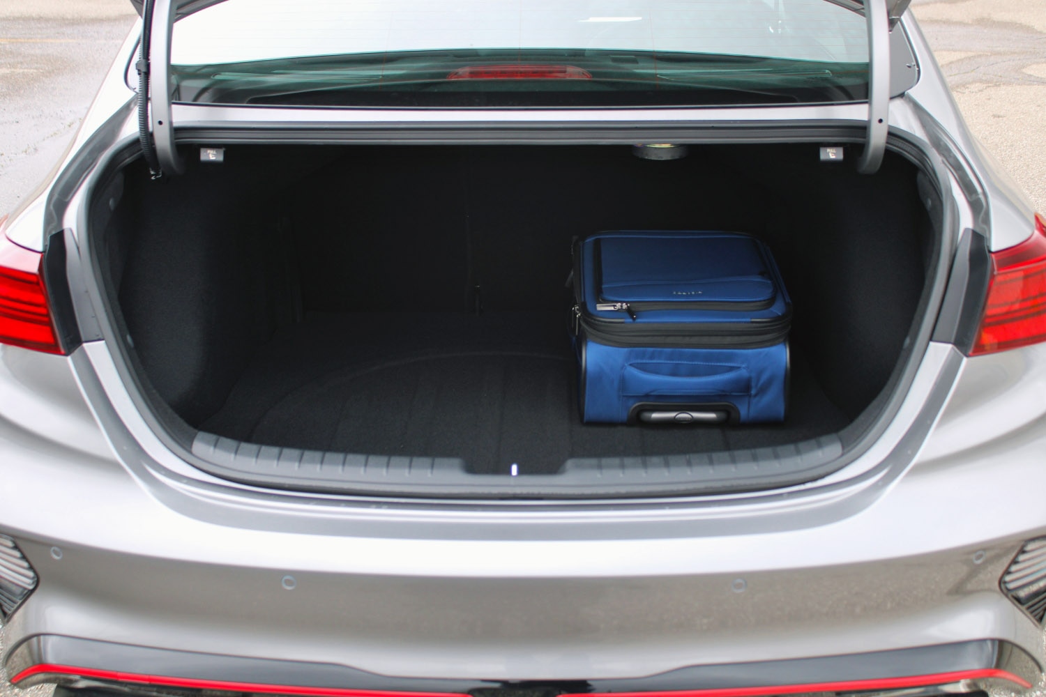2022 Kia Forte GT with trunk open, showing cargo space with carry-on luggage bag inside