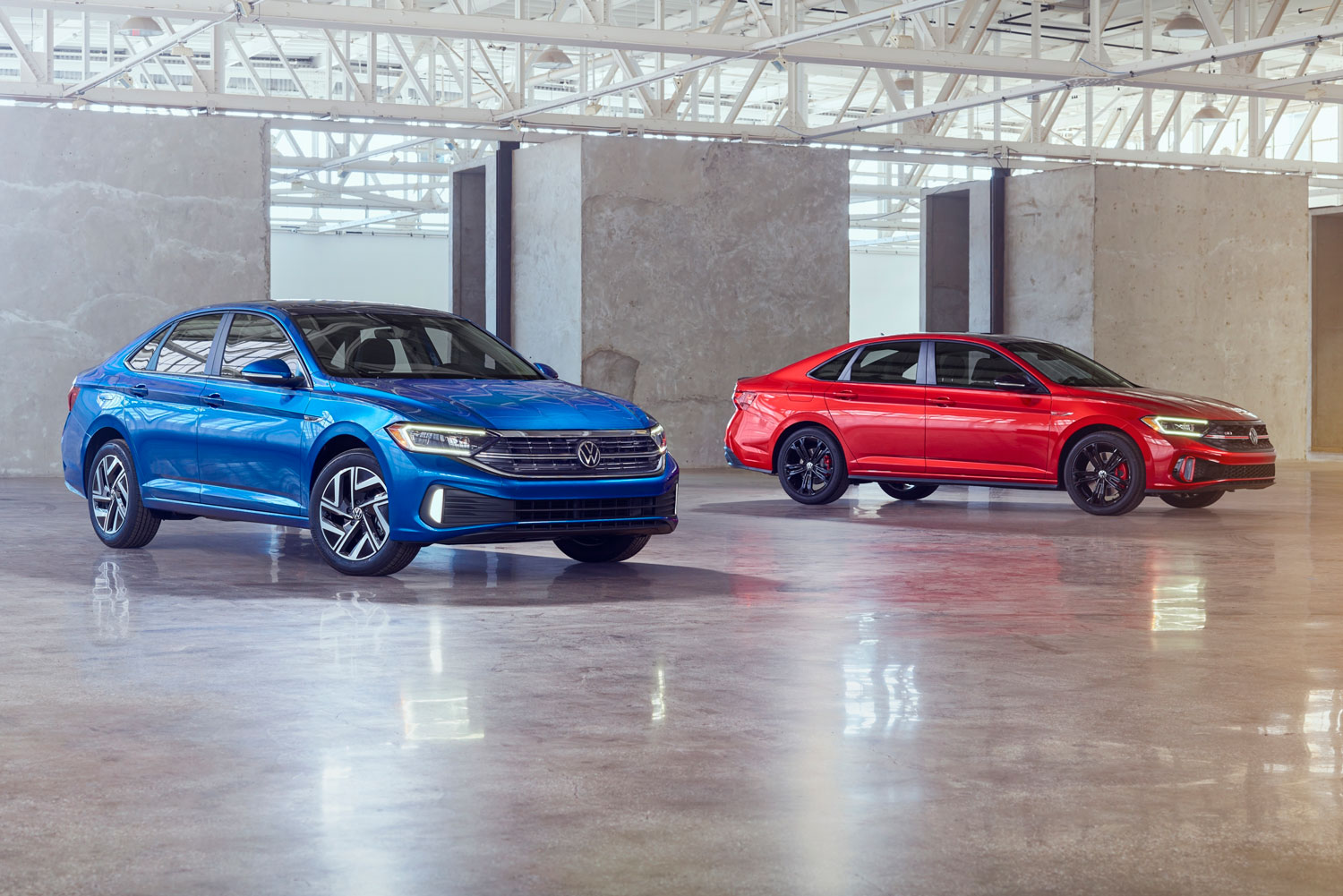 two 2023 Volkswagen Jettas parked, one red one blue