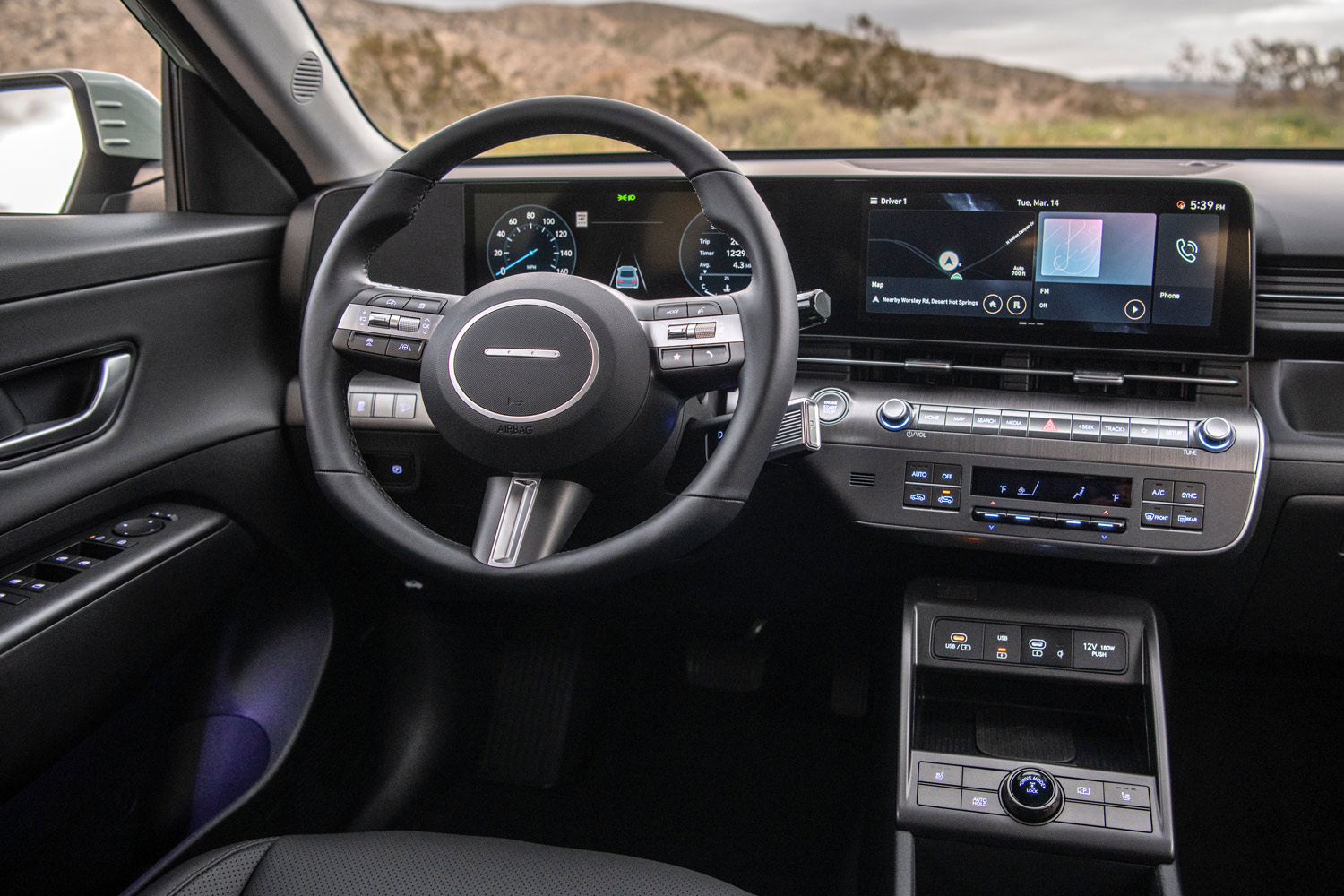 Interior of a 2024 Hyundai Kona showing a large infotainment touchscreen and steering wheel