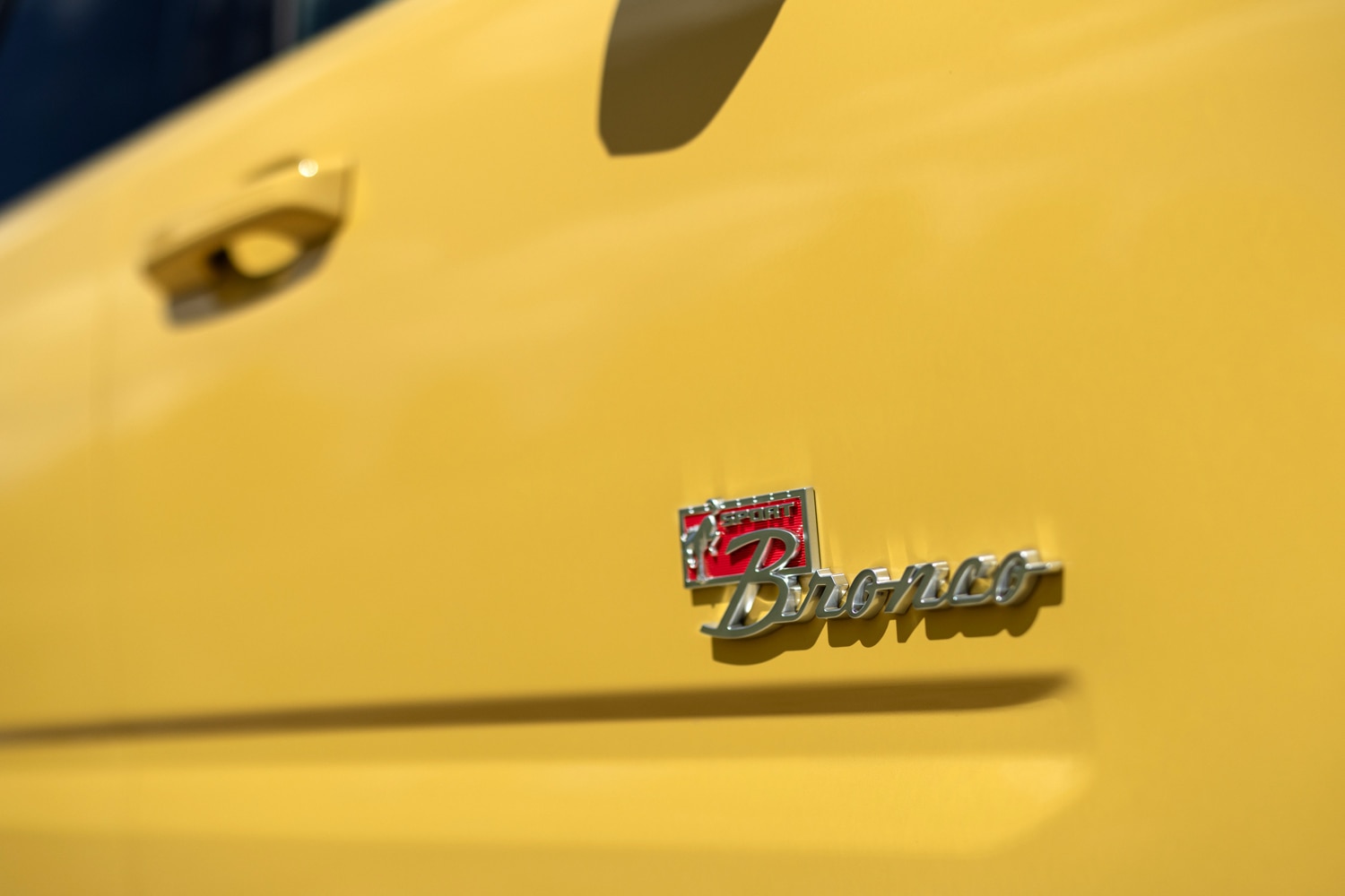 A closeup view of the logo on a yellow 2023 Ford Bronco Sport