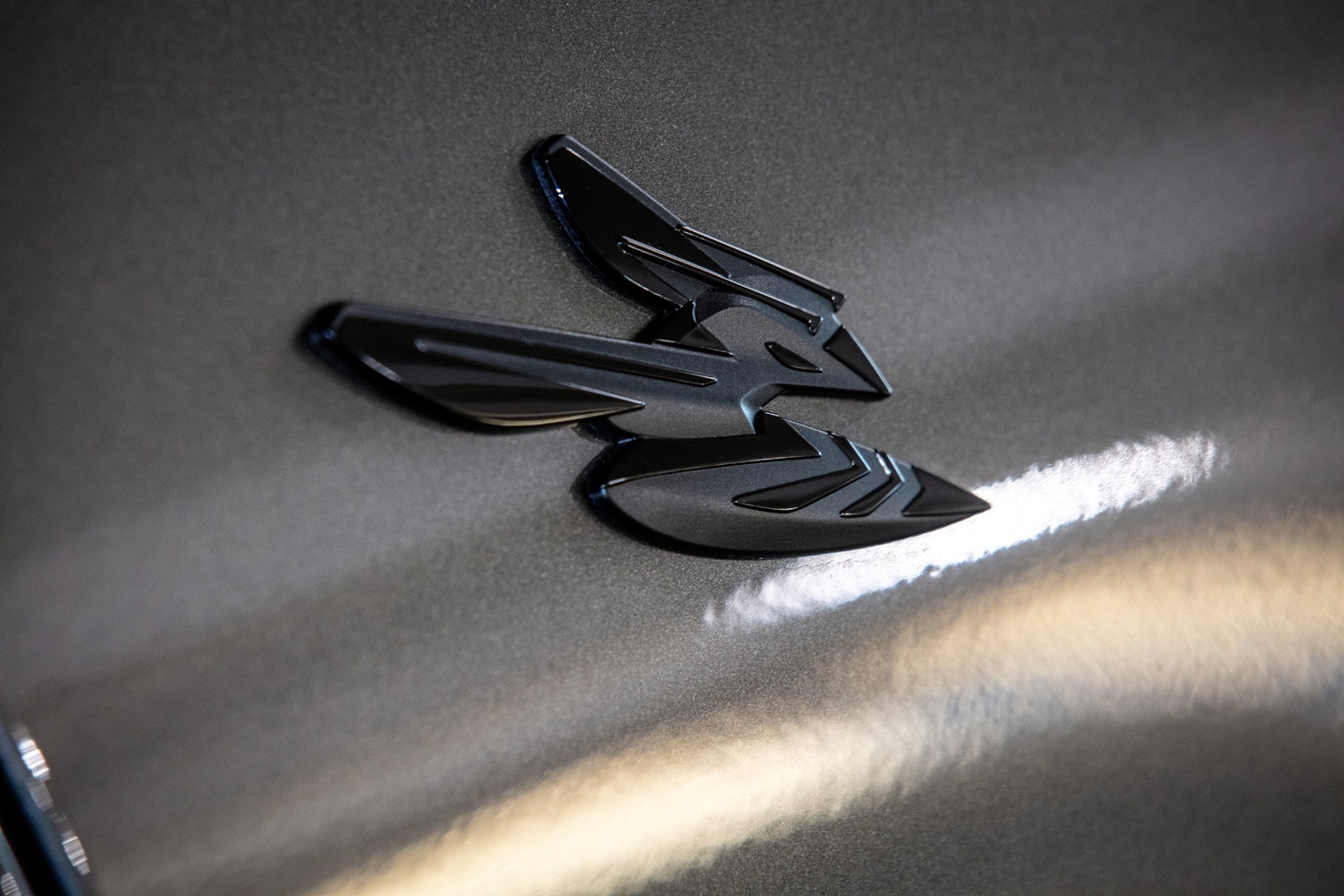 A closeup view of the logo on a silver 2023 Dodge Hornet