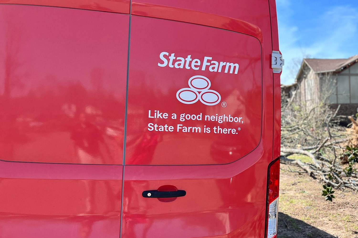 Closeup of red State Farm roadside assistance Ford Transit van