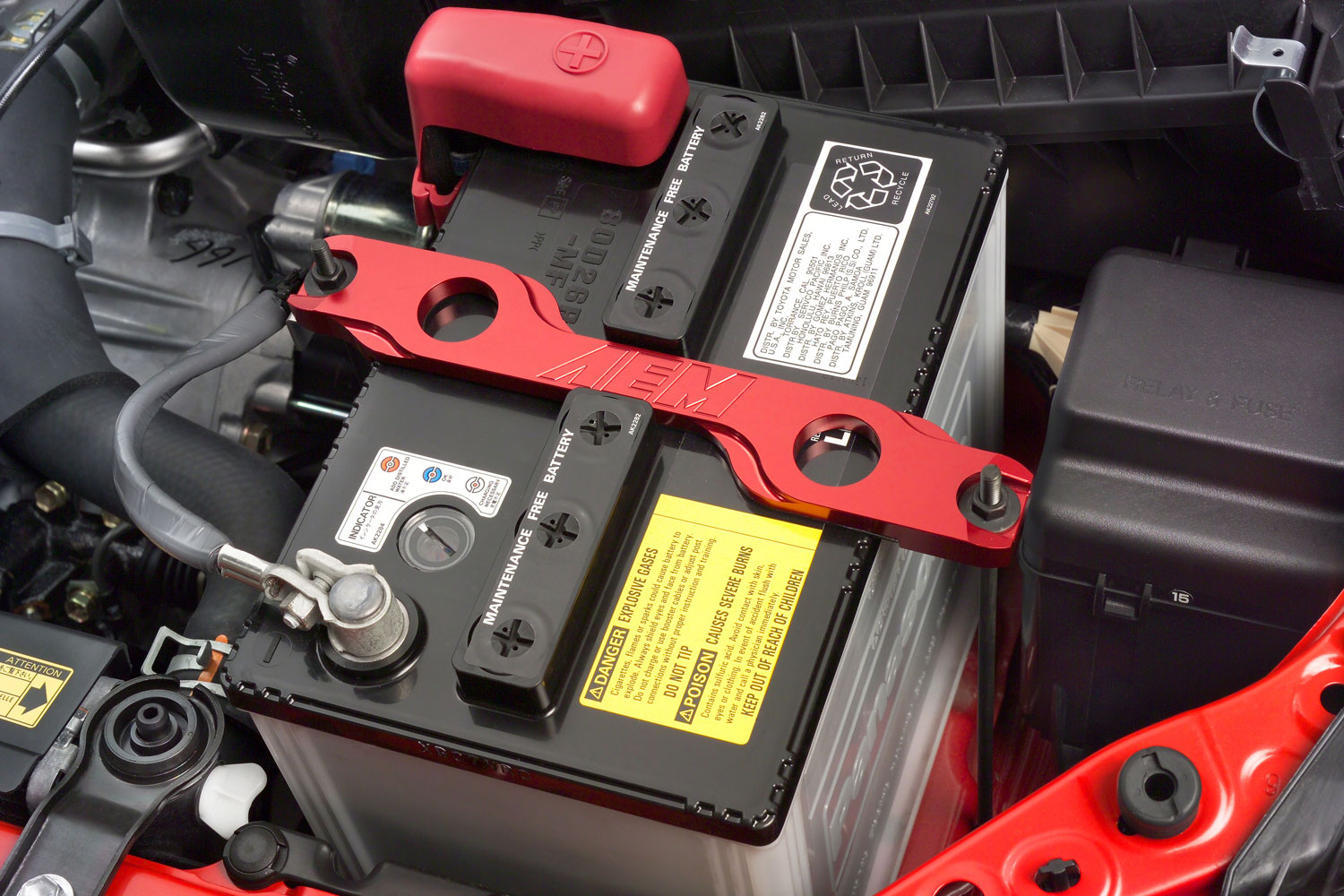 A battery is secured within a  car's engine compartment