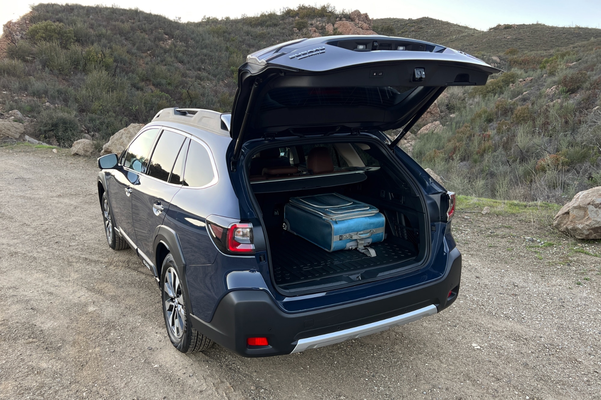 Cosmic Blue 2023 Subaru Outback open cargo space with luggage inside