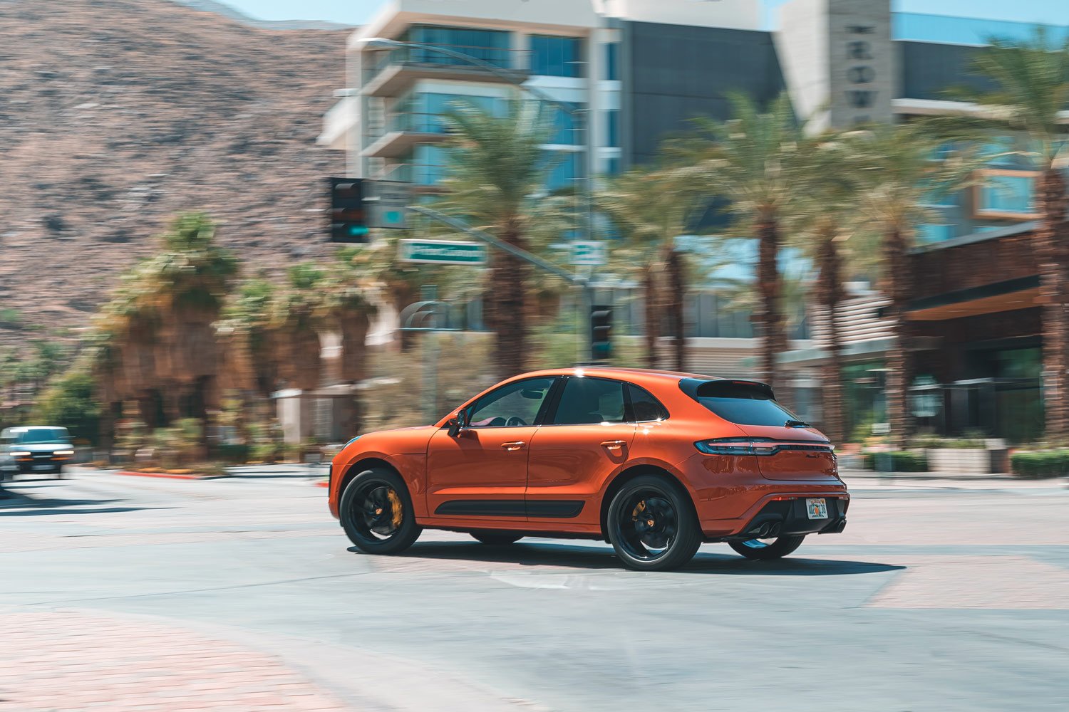 Side view of an orange 2023 Porsche Macan