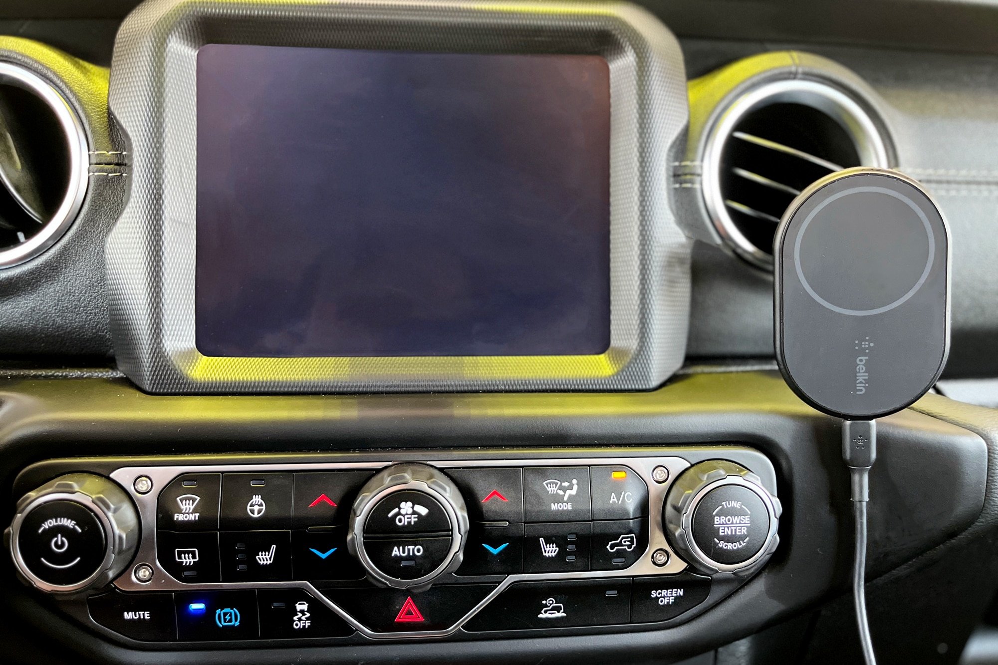 Belkin MagSafe mobile wireless car charger plugged into a Jeep Wrangler's dashboard