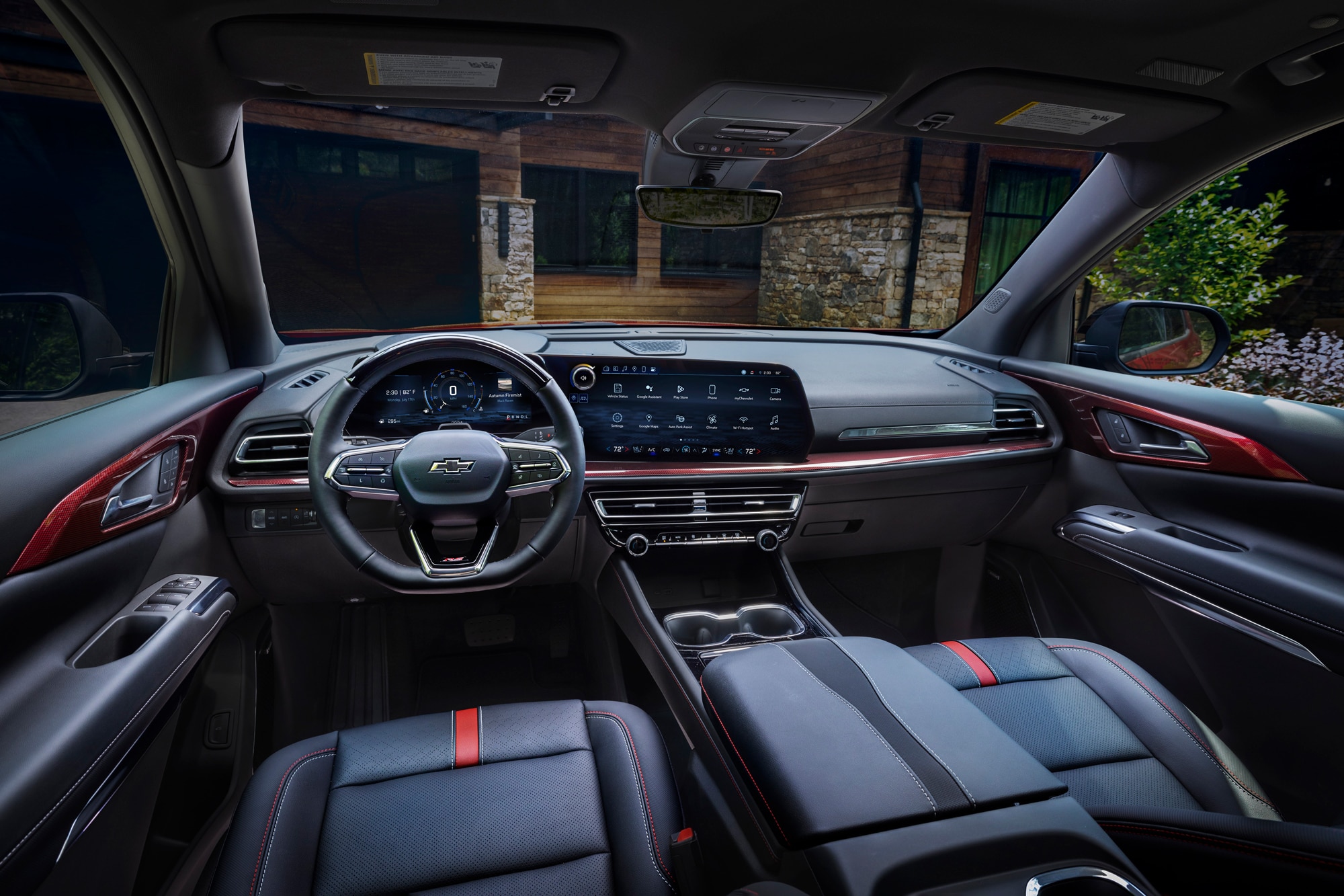 Wide view of front seats in 2024 Chevrolet Traverse RS with jet-black and red accent interior