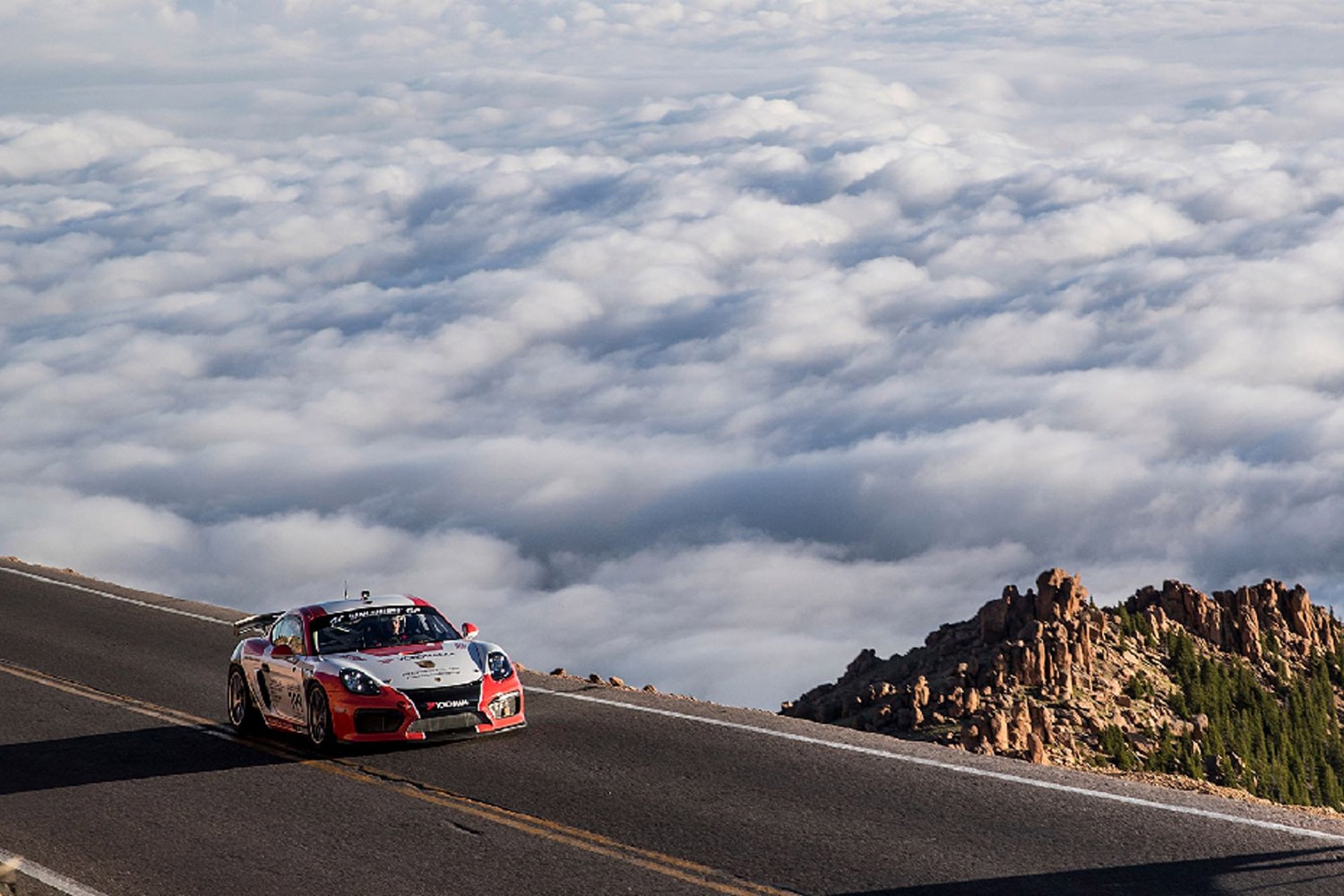 Front three-quarter view of a Porsche above the clouds on Pikes Peak