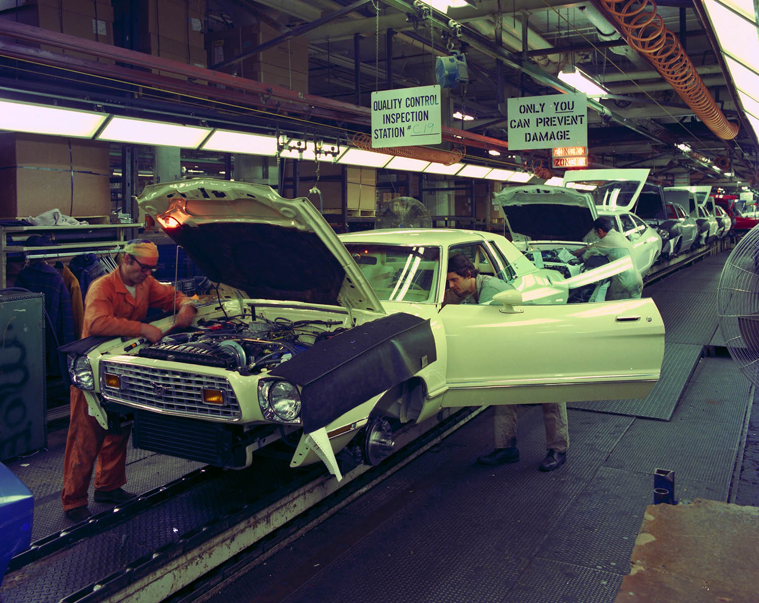 Workers performing quality control near the end of the Ford Mustang II production line at the Dearborn Assembly Plant in 1975