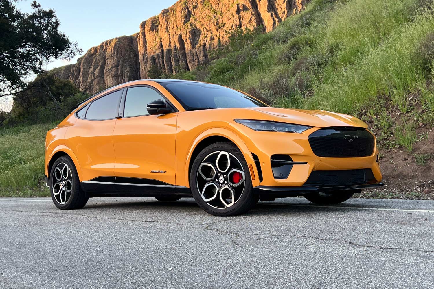 2023 Ford Mustang Mach-E GT in Cyber Orange parked on country road