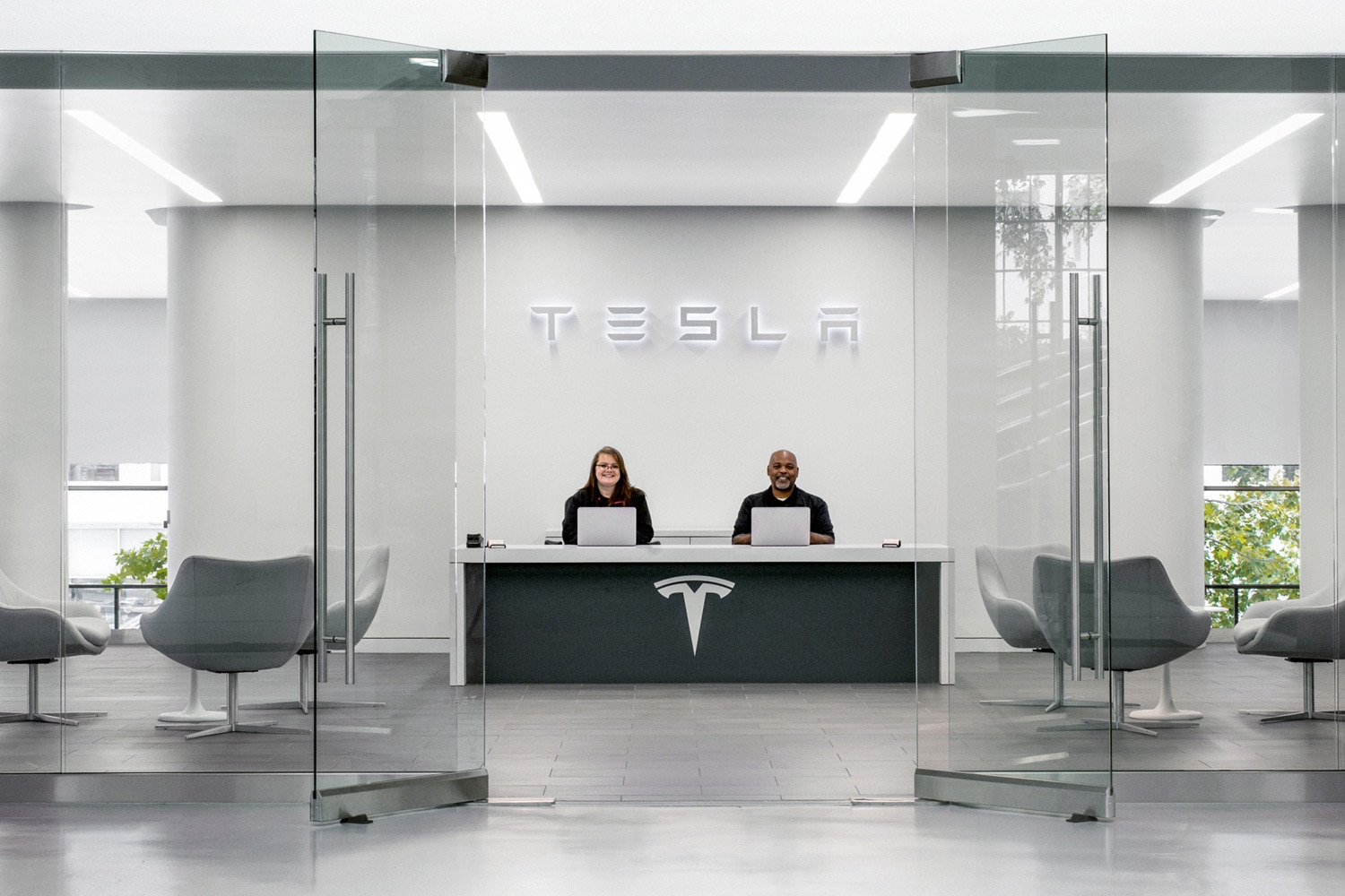 Two service representatives for Tesla sitting at desk