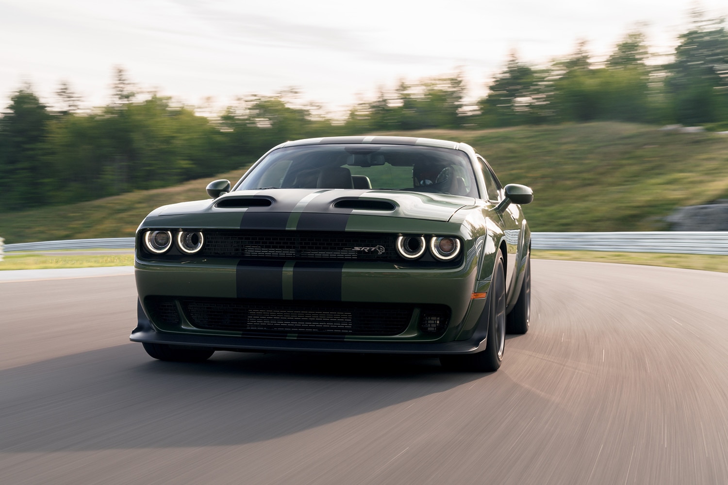 2023 Dodge Challenger SRT Hellcat Widebody in F8 Green with dual carbon stripes navigating a sweeper on a track