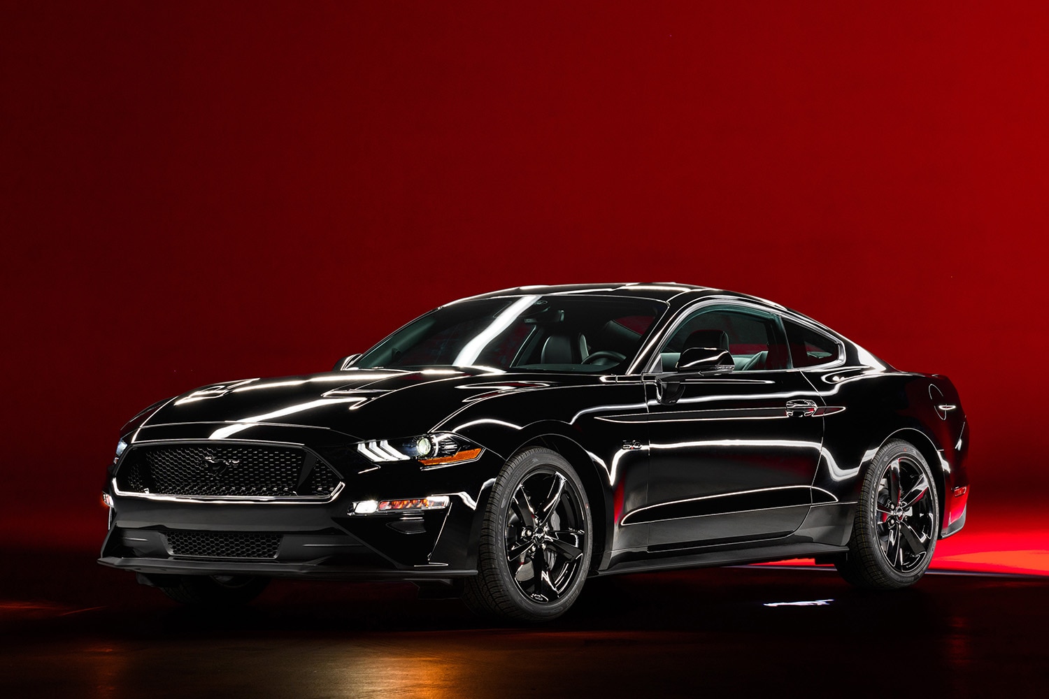 Ford Mustang EcoBoost Fastback in black, shot in a studio with a crimson backdrop