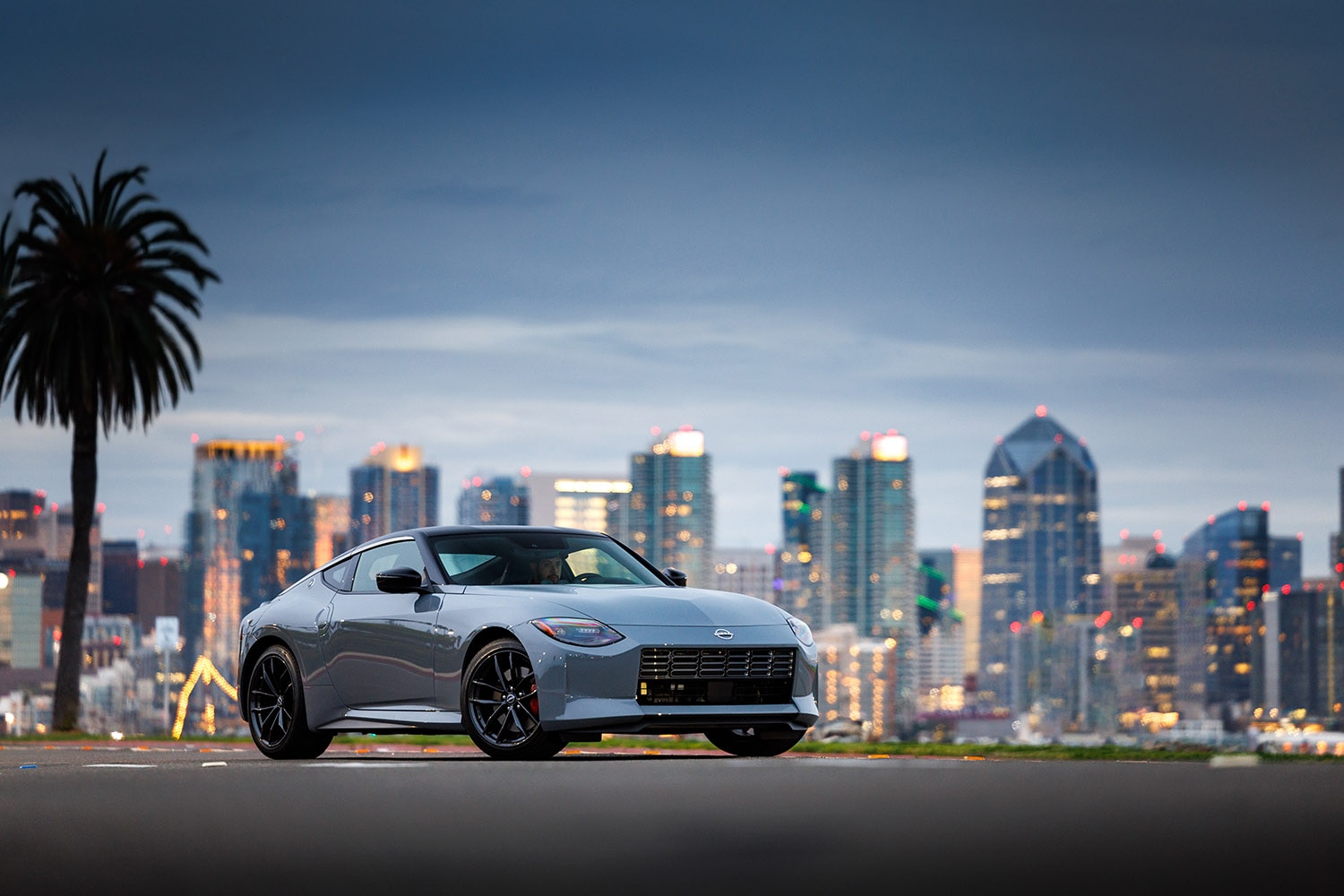 2023 Nissan Z in Boulder Gray parked in front of a city skyline in the evening