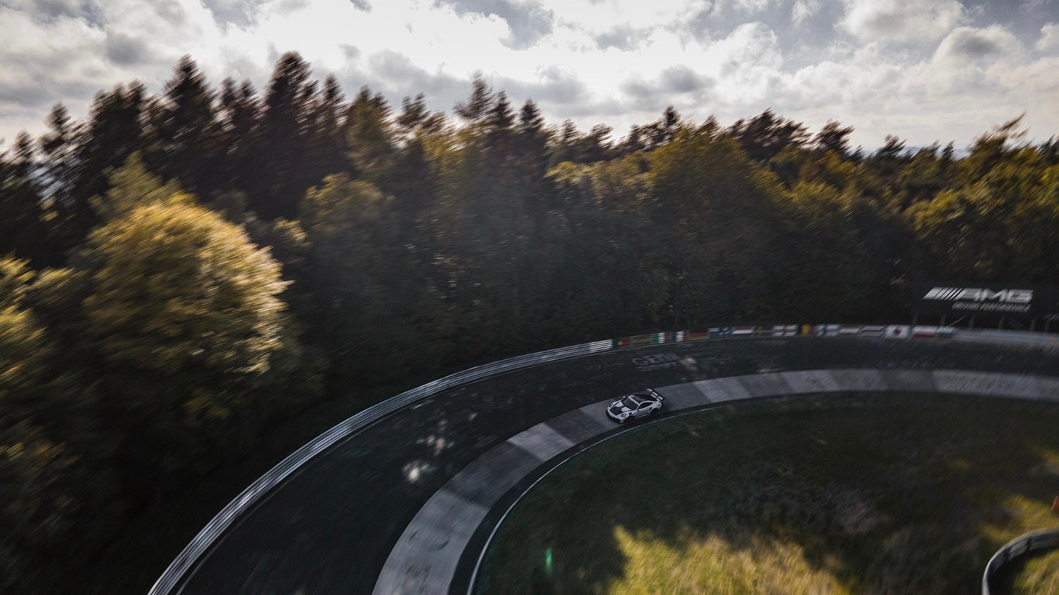 Bird's eye shot of a Porsche 911 GT3 RS driving on a curve of the Nundefinedrburgring